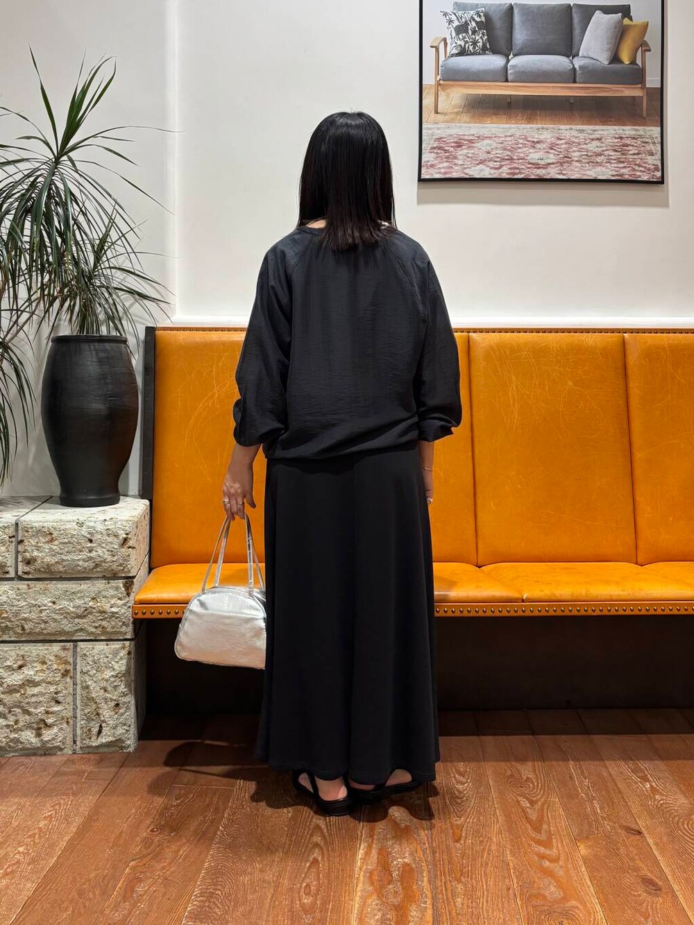 ブラック系のスカート、シルバー系のボストンバッグ、ブラック系のカーディガン/ボレロを着用したレディースの夏コーディネートの3枚目の写真