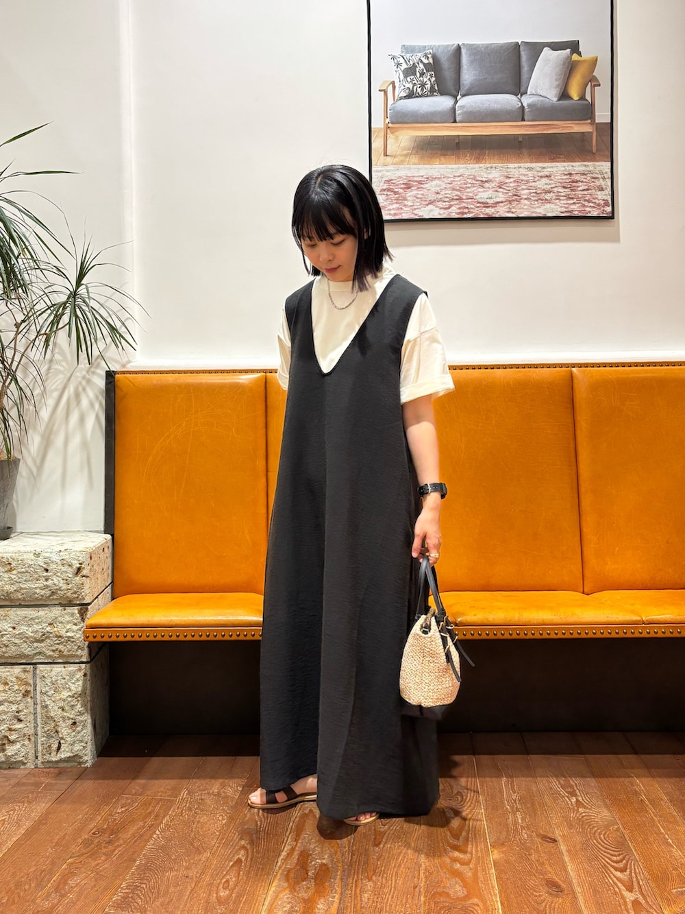 ブラック系のワンピース、ホワイト系のTシャツ/カットソー、ブラウン系のサンダルを着用したレディースの夏コーディネートの2枚目の写真