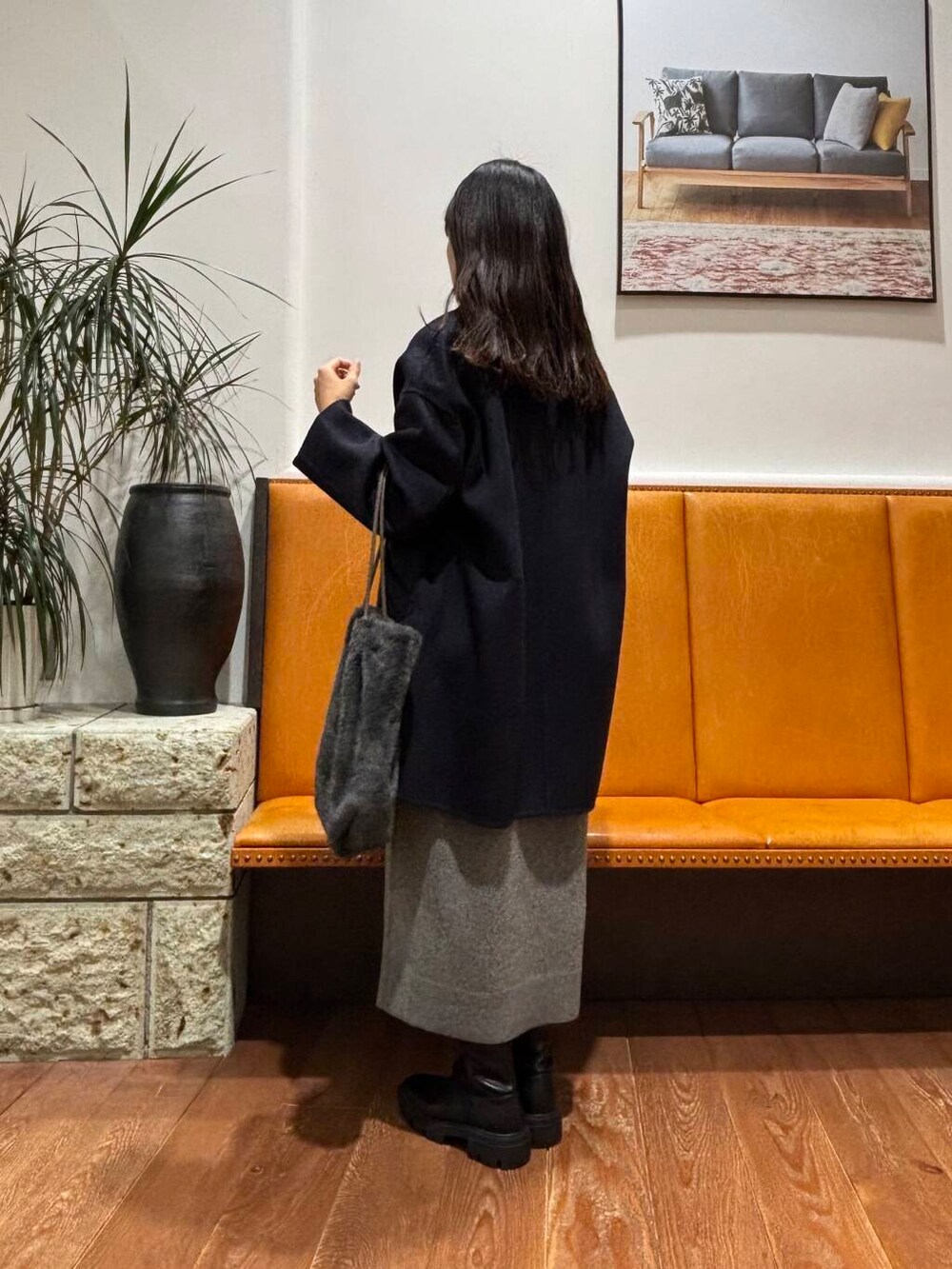 ブルー系のその他アウター、ブラック系のブーツ、グレー系のトートバッグを着用したレディースの冬コーディネートの2枚目の写真