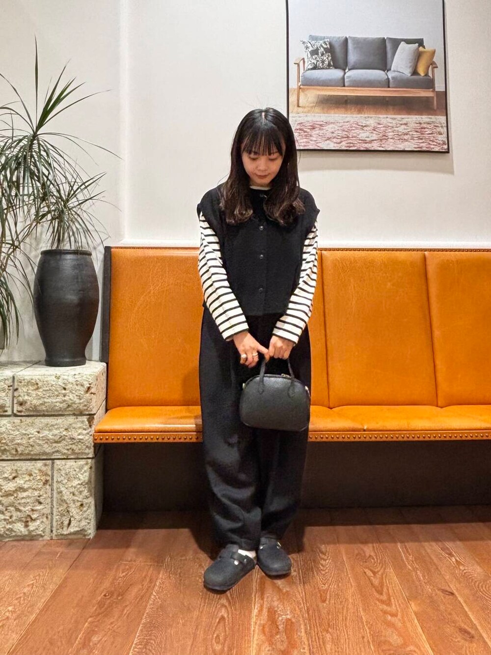 ブラック系のショルダーバッグ、ブラック系のその他パンツ、ブラック系のTシャツ/カットソーを着用したレディースの冬コーディネートの3枚目の写真