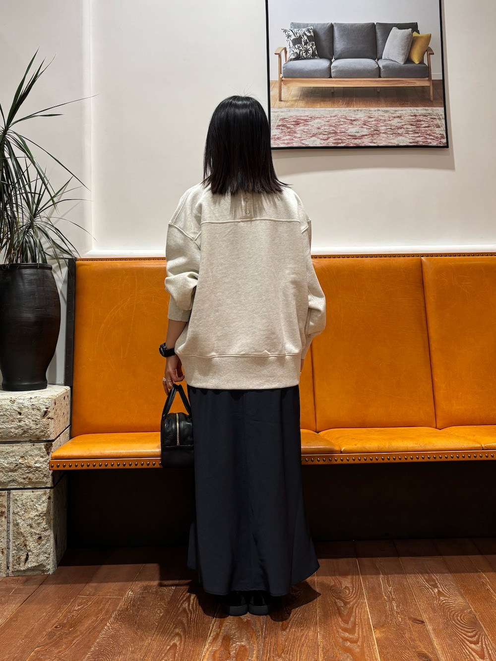 ベージュ系のスウェット、ブルー系のスカート、ブラック系のその他シューズを着用したレディースの冬コーディネートの3枚目の写真