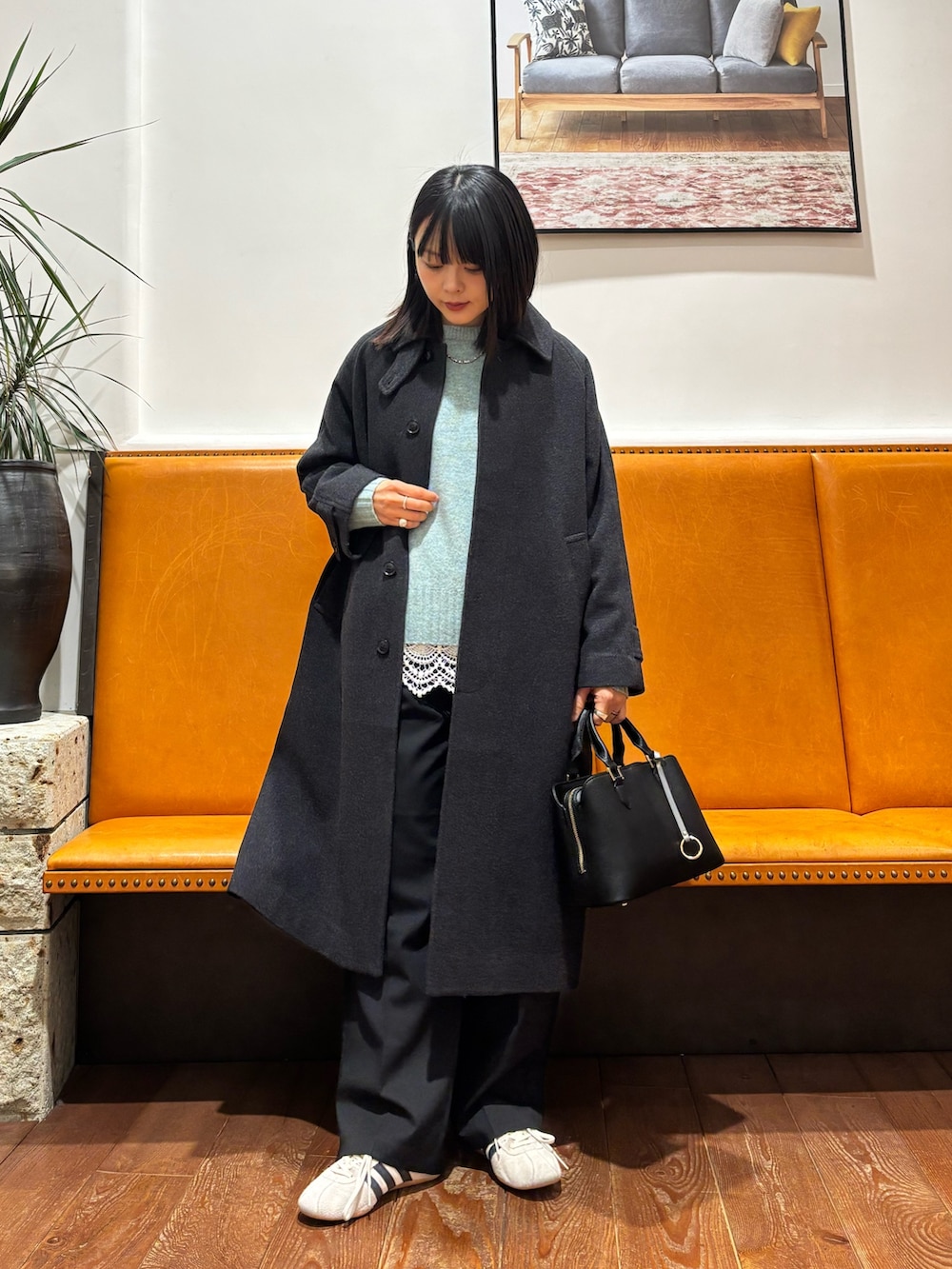 グリーン系のニット/セーター、ホワイト系のTシャツ/カットソー、ブラック系のその他パンツを着用したレディースの冬コーディネートの2枚目の写真