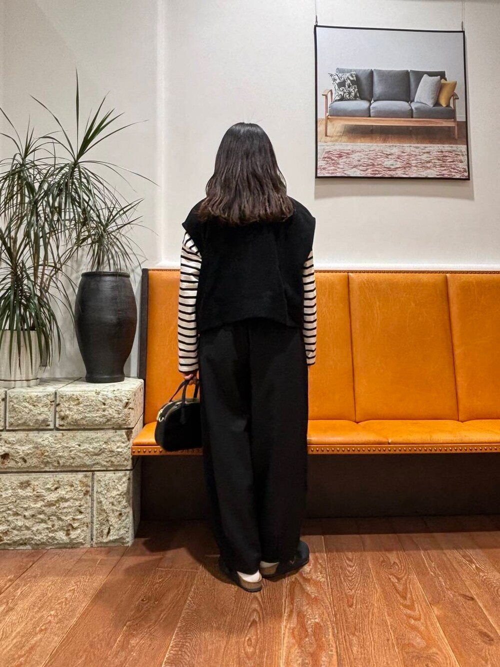 ブラック系のショルダーバッグ、ブラック系のその他パンツ、ブラック系のTシャツ/カットソーを着用したレディースの冬コーディネートの2枚目の写真