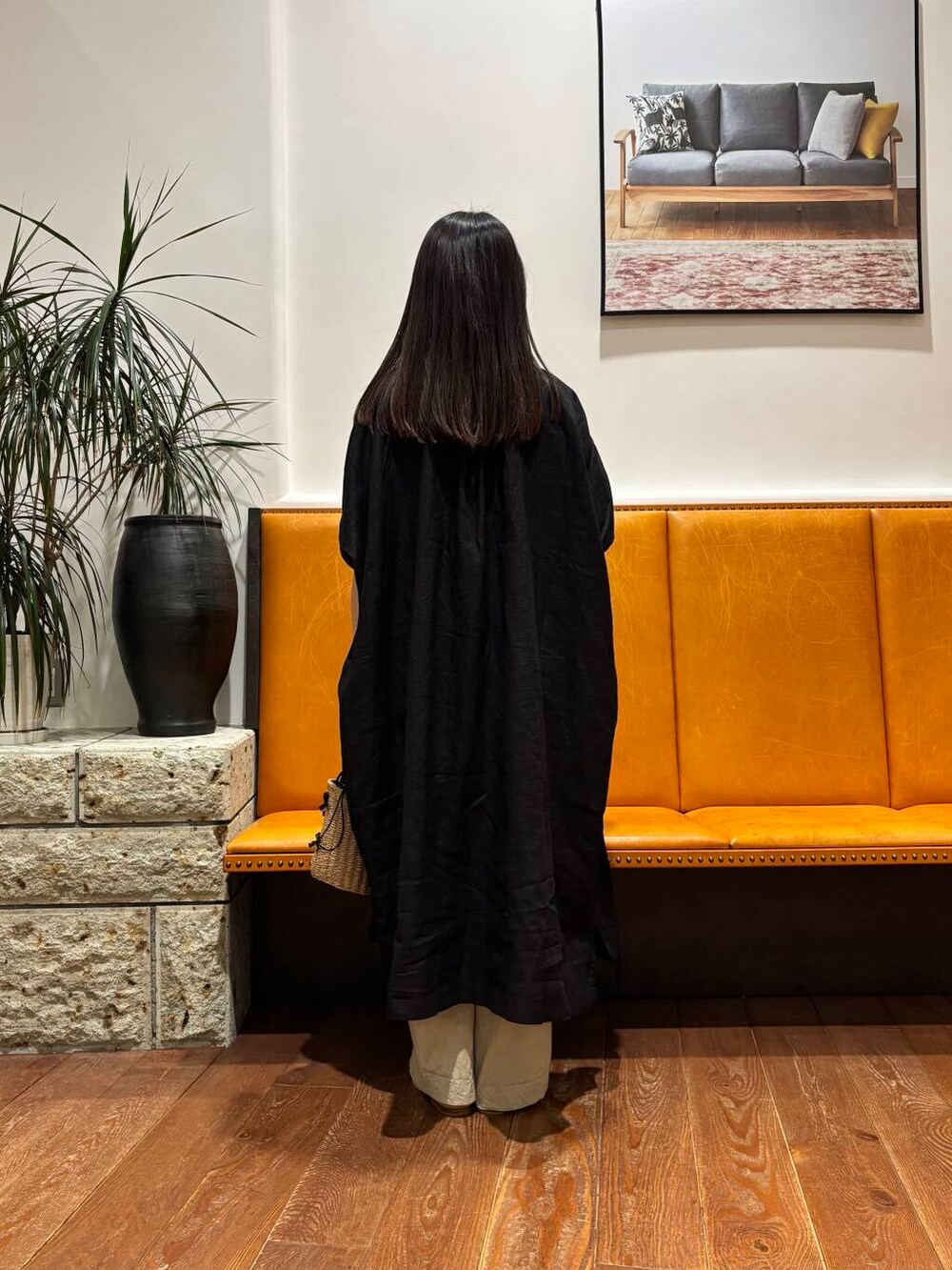 イエロー系のショルダーバッグ、ホワイト系のサンダル、ブラック系のワンピースを着用したレディースの春コーディネートの4枚目の写真