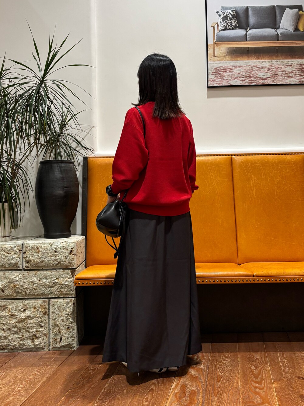 レッド系のニット/セーター、グレー系のスカート、ブラック系のショルダーバッグを着用したレディースの秋コーディネートの3枚目の写真