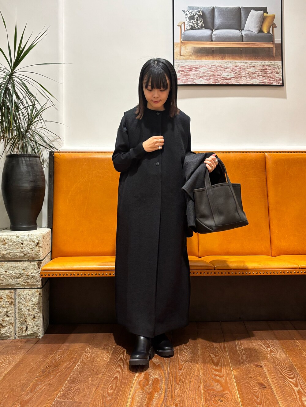 グレー系のその他アウター、グレー系のトートバッグ、ブラック系のジャンパースカートを着用したレディースの秋コーディネートの2枚目の写真