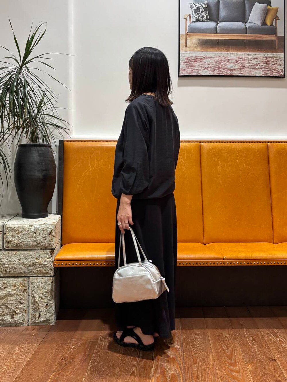 ブラック系のスカート、シルバー系のボストンバッグ、ブラック系のカーディガン/ボレロを着用したレディースの夏コーディネートの2枚目の写真