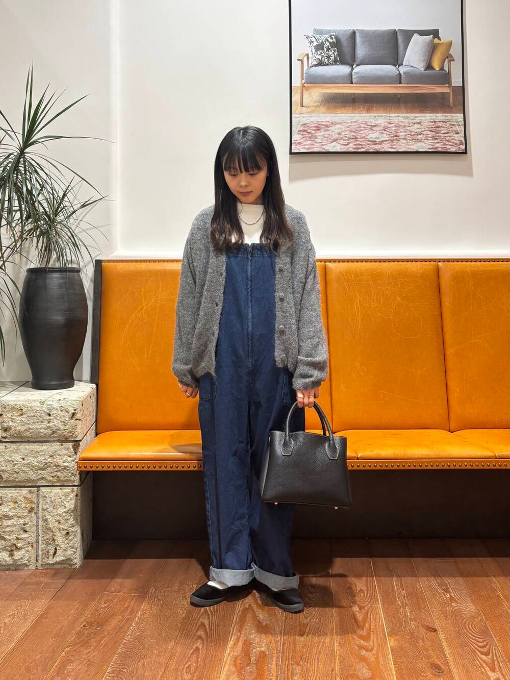 グレー系のカーディガン/ボレロ、ブラック系のショルダーバッグ、ブルー系のサロペット/オーバーオールを着用したレディースの冬コーディネートの3枚目の写真