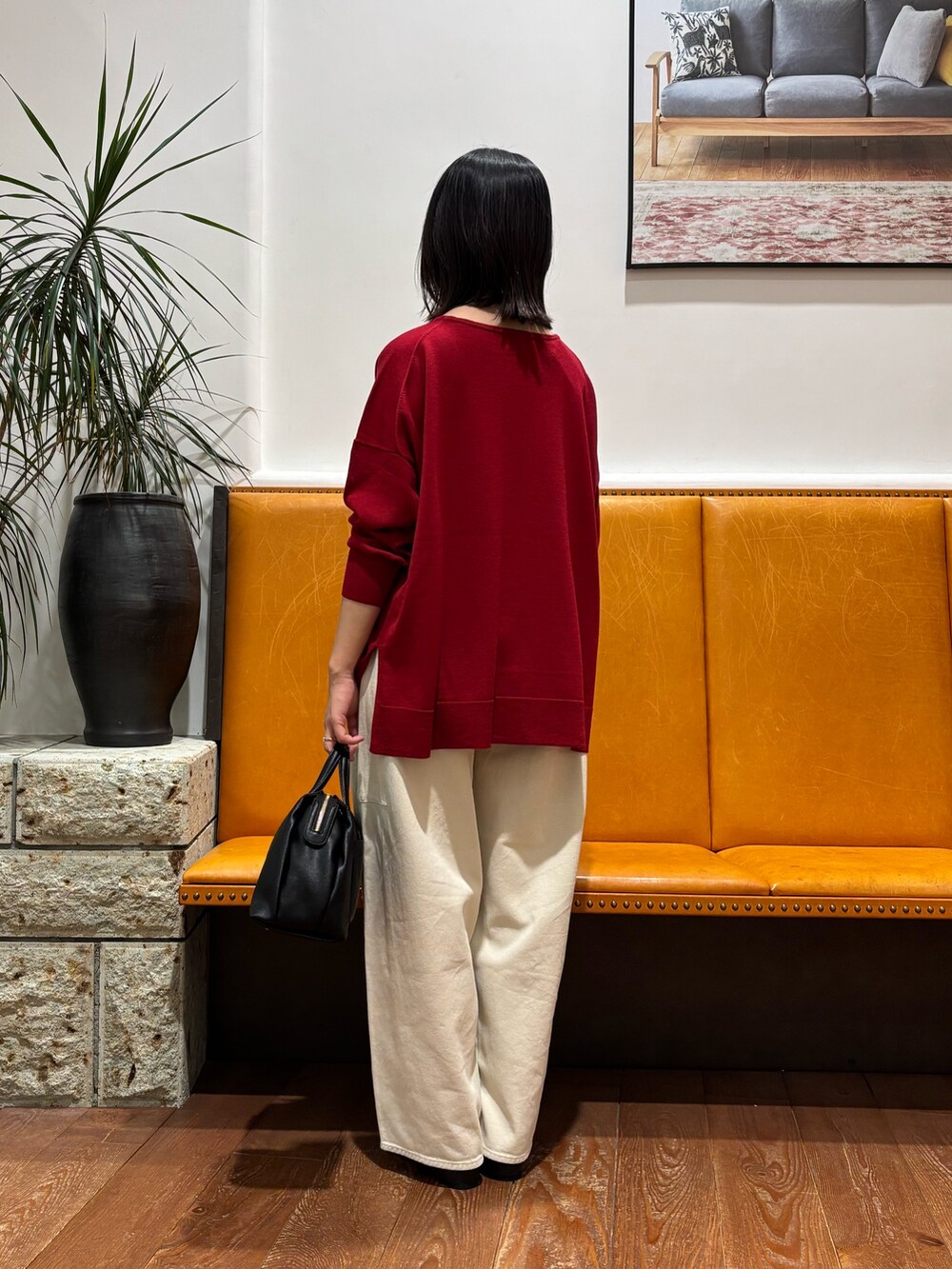 レッド系のニット/セーター、ホワイト系のその他パンツを着用したレディースの秋コーディネートの2枚目の写真