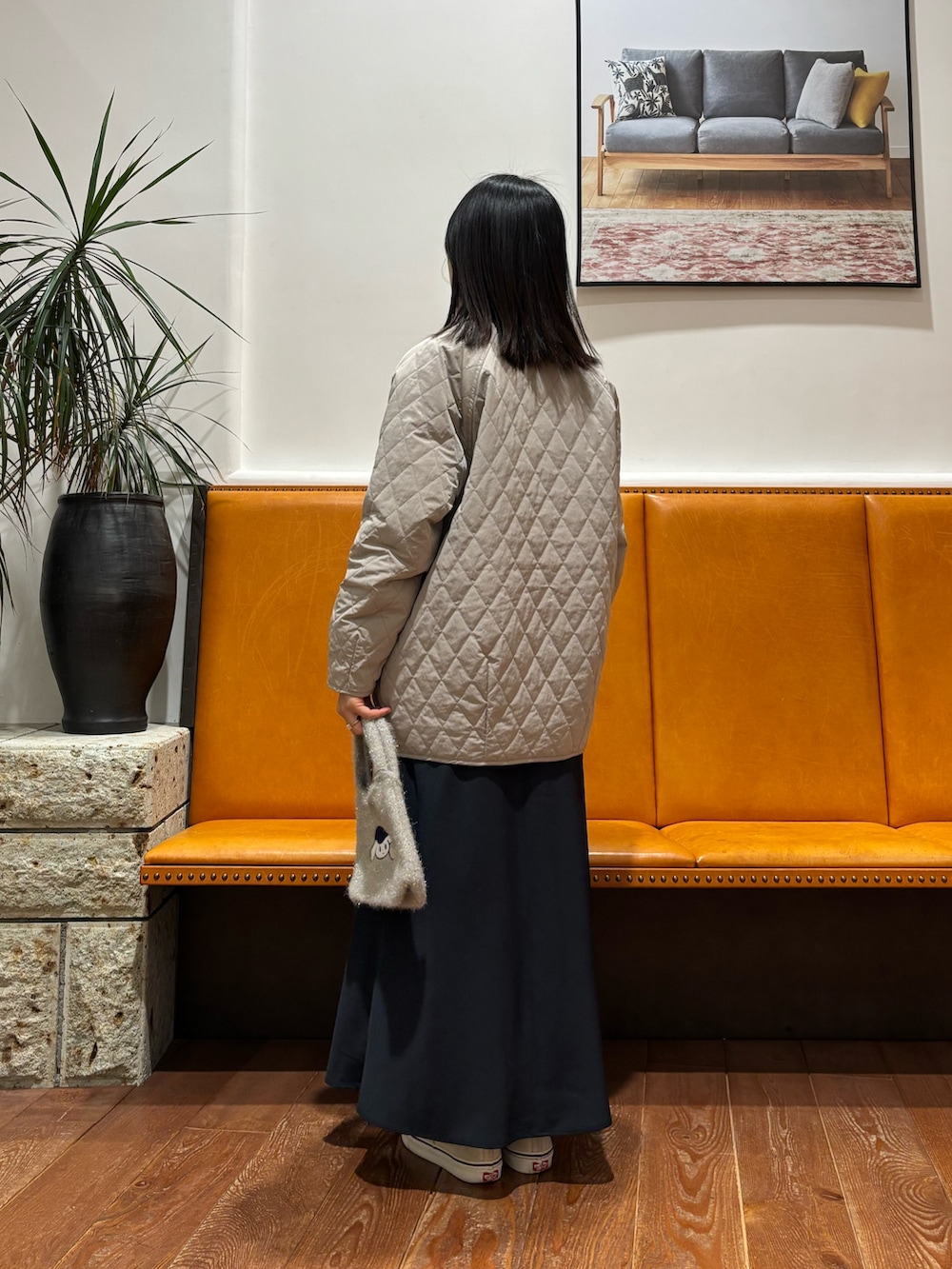 グレー系のダウンジャケット/コート、ブルー系のTシャツ/カットソー、ブルー系のスカートを着用したレディースの冬コーディネートの2枚目の写真