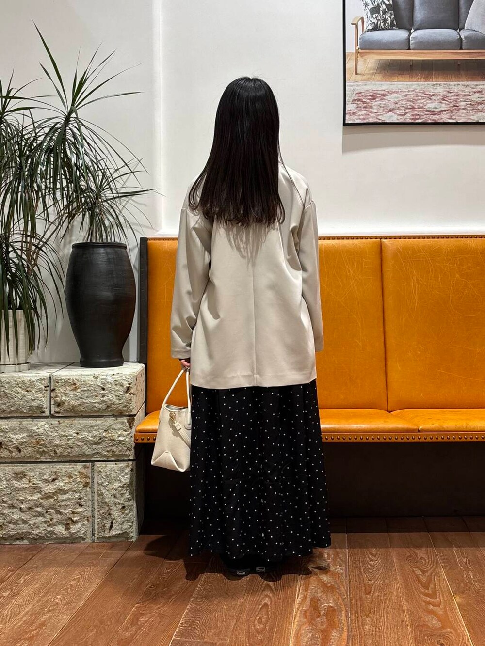 ベージュ系のその他アウター、ホワイト系のショルダーバッグ、ブラック系のワンピースを着用したレディースの春コーディネートの3枚目の写真