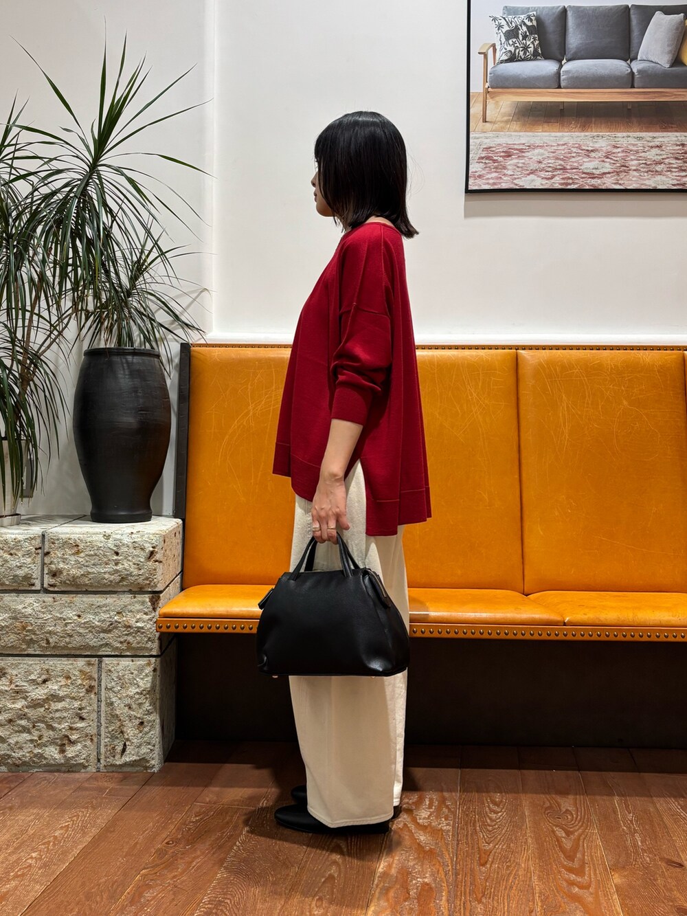 レッド系のニット/セーター、ホワイト系のその他パンツを着用したレディースの秋コーディネートの3枚目の写真