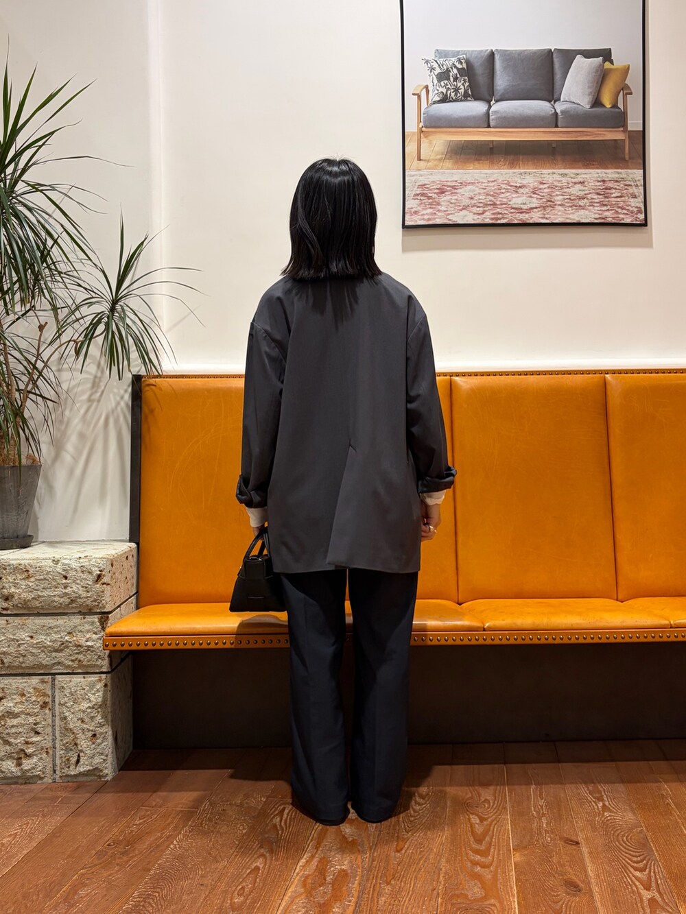 ブラック系のハンドバッグ、ブルー系のその他パンツ、ホワイト系のTシャツ/カットソーを着用したレディースの秋コーディネートの2枚目の写真