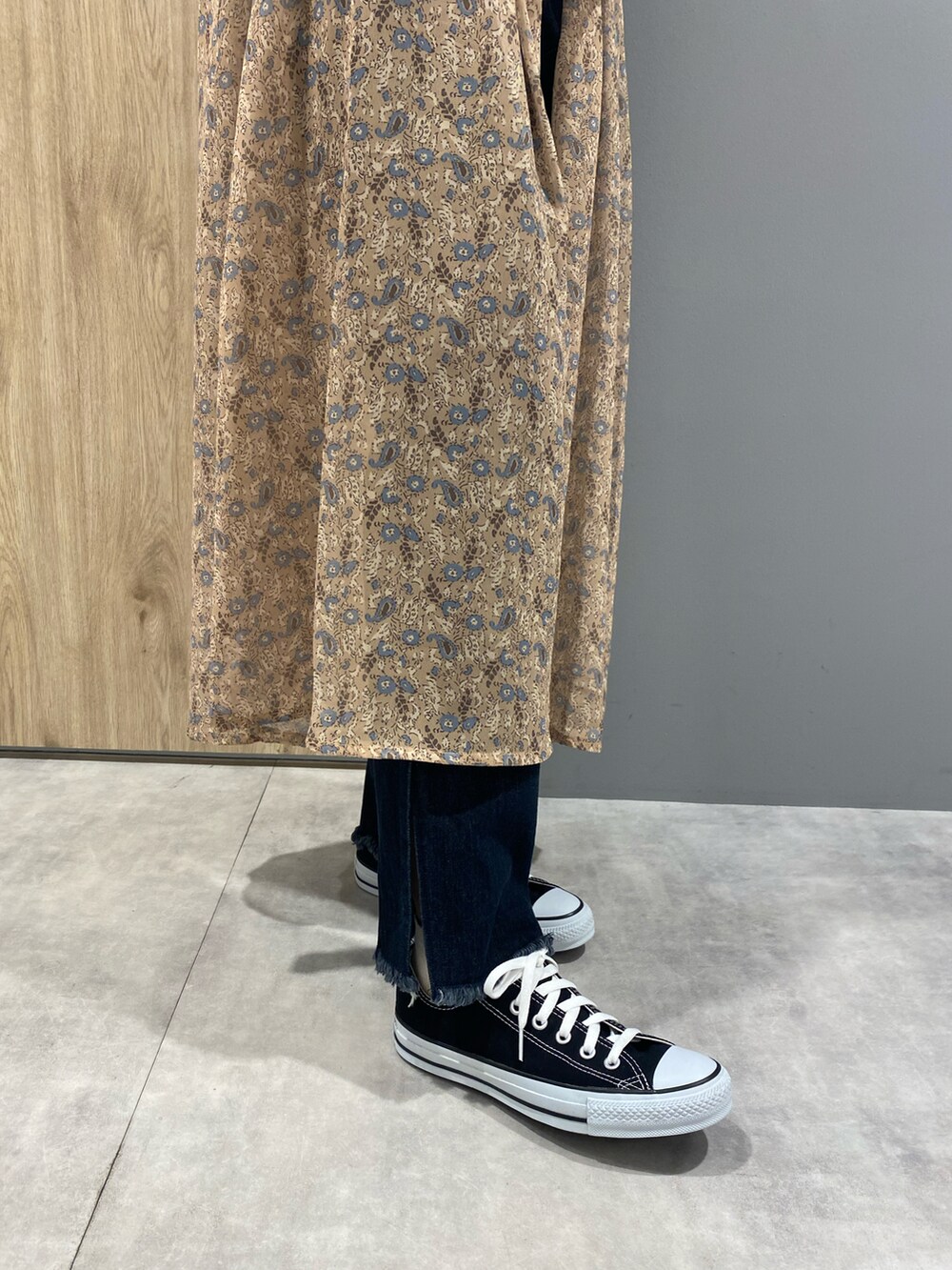 オレンジ系のTシャツ/カットソー、ベージュ系のワンピース、ブルー系のデニムパンツを着用したレディースの夏コーディネートの2枚目の写真