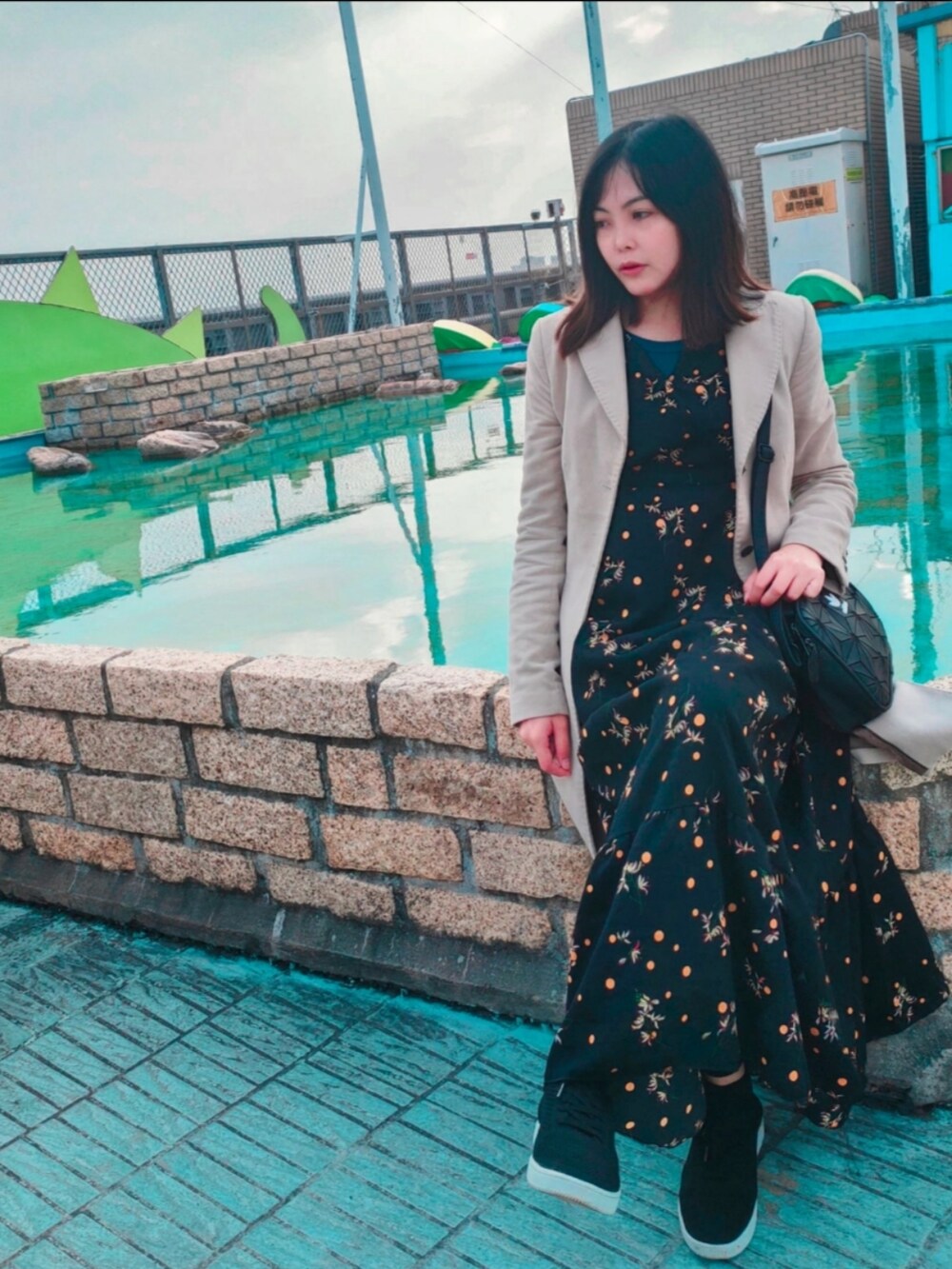 ブラック系のショルダーバッグ、グレー系のチェスターコートを着用したレディースの冬コーディネートの2枚目の写真