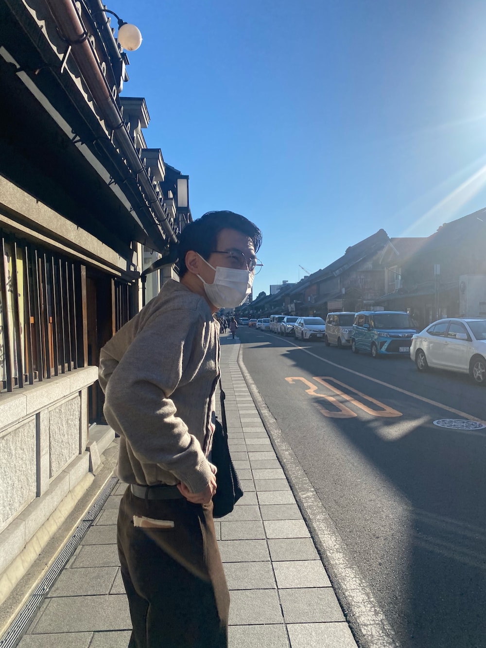 ブラウン系のパンツ、ベージュ系のニット/セーター、ブルー系のドレスシューズを着用したメンズの秋コーディネートの2枚目の写真