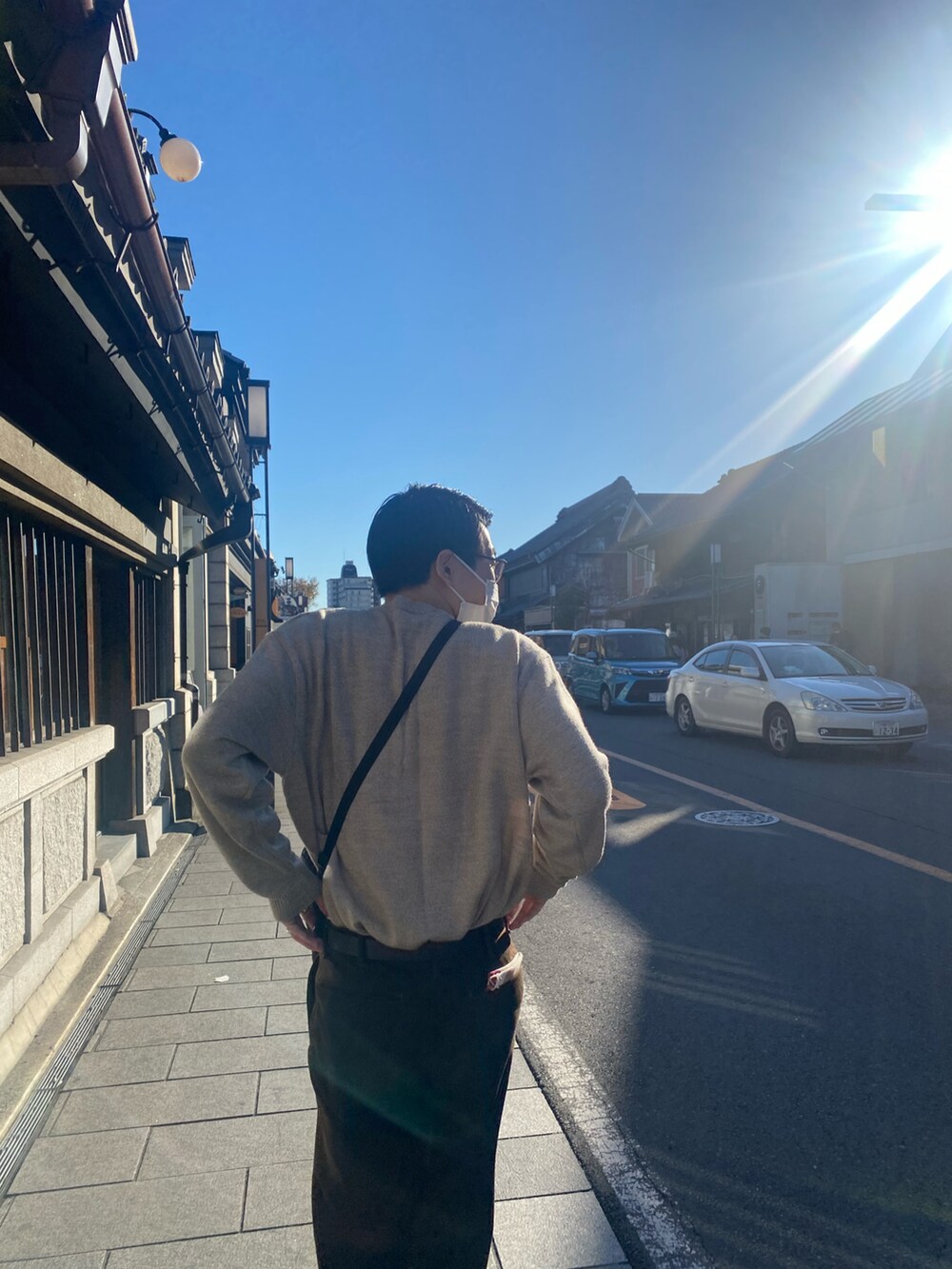 ブラウン系のパンツ、ベージュ系のニット/セーター、ブルー系のドレスシューズを着用したメンズの秋コーディネートの3枚目の写真