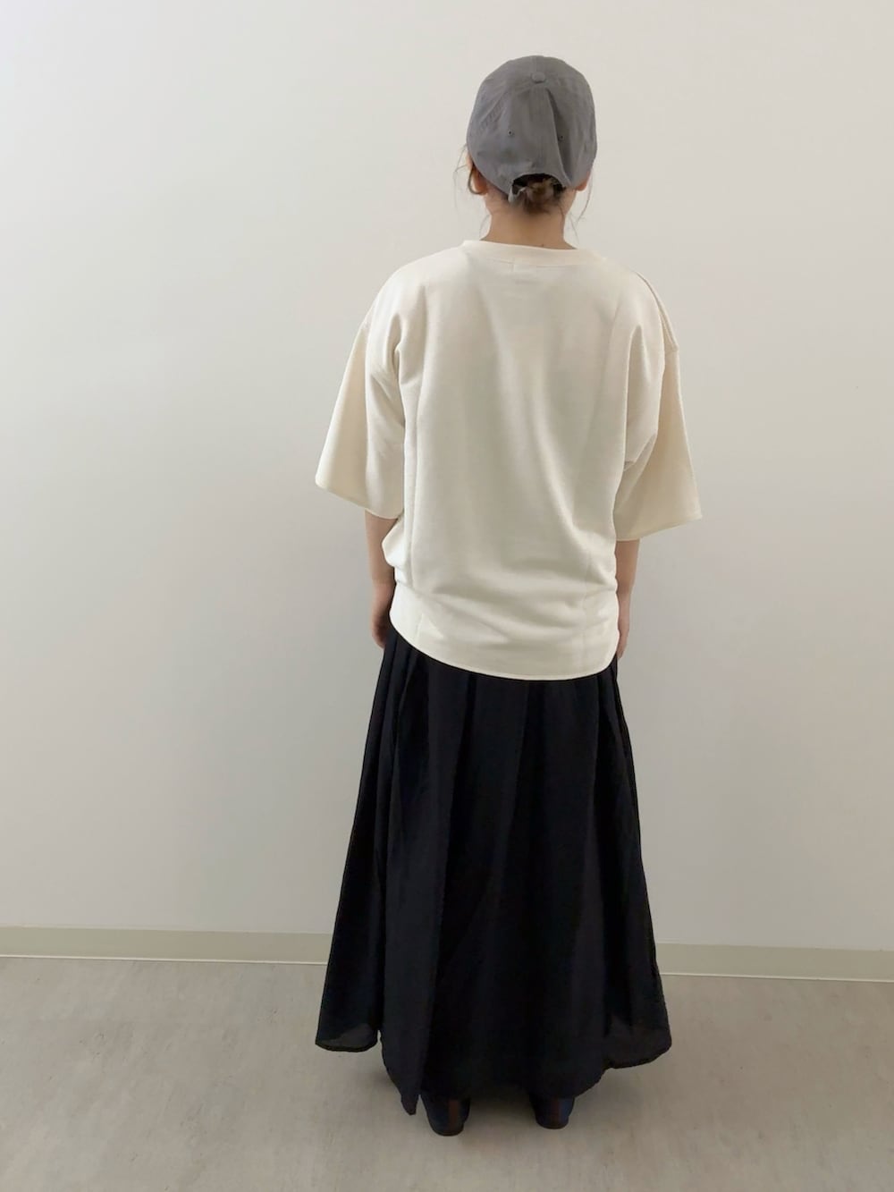 ブラック系のスカート、ホワイト系のTシャツ/カットソー、ブルー系のパンプスを着用したレディースの秋コーディネートの3枚目の写真