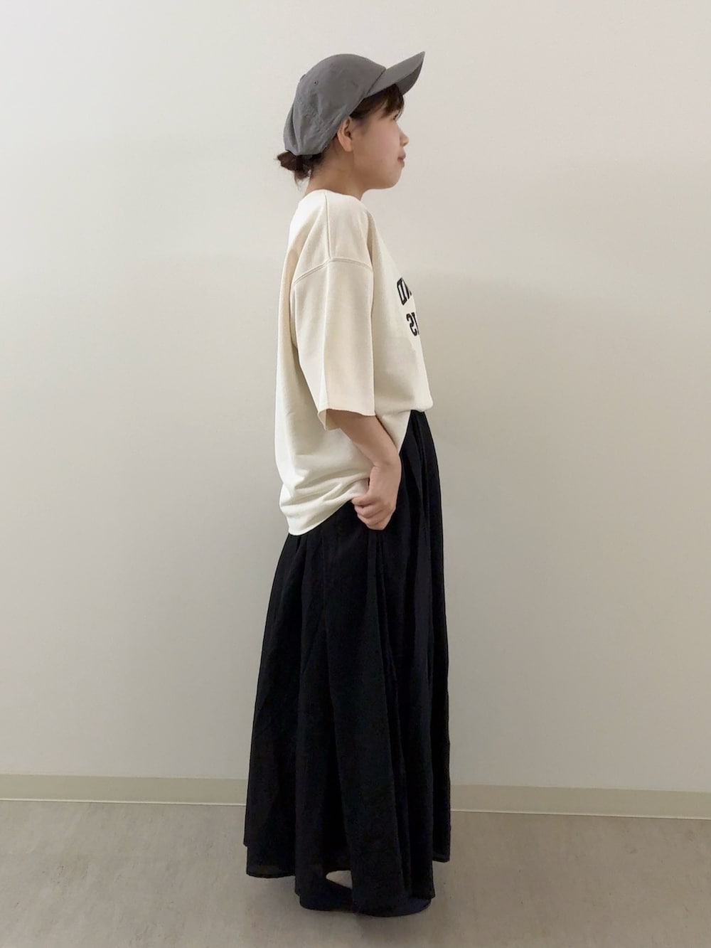 ブラック系のスカート、ホワイト系のTシャツ/カットソー、ブルー系のパンプスを着用したレディースの秋コーディネートの2枚目の写真
