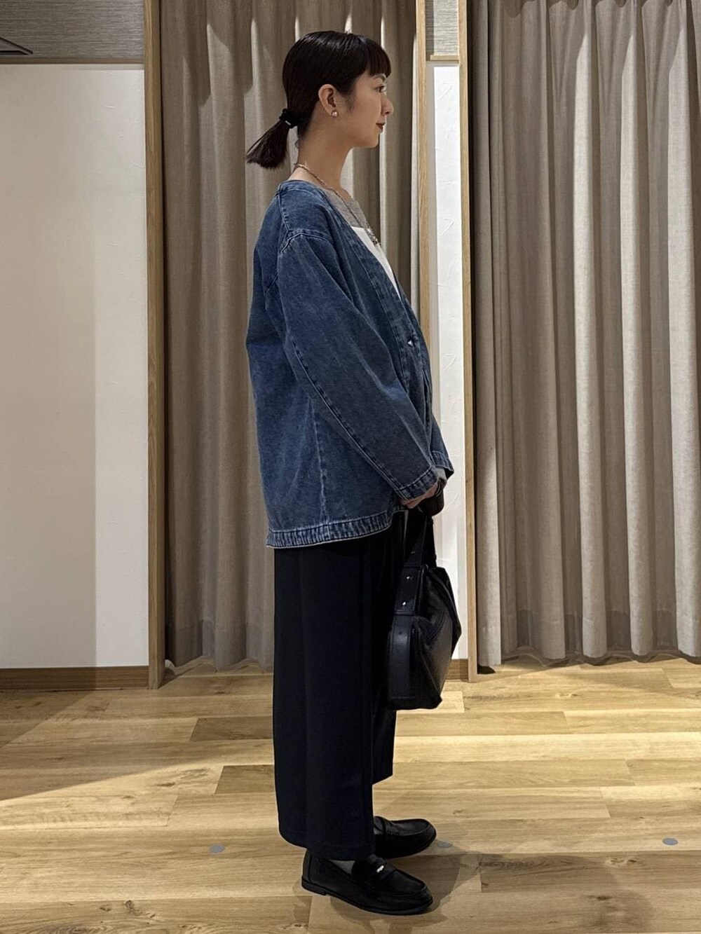 ブルー系のノーカラージャケット、ブラック系のローファー、ブラック系のショルダーバッグを着用したレディースの冬コーディネートの4枚目の写真