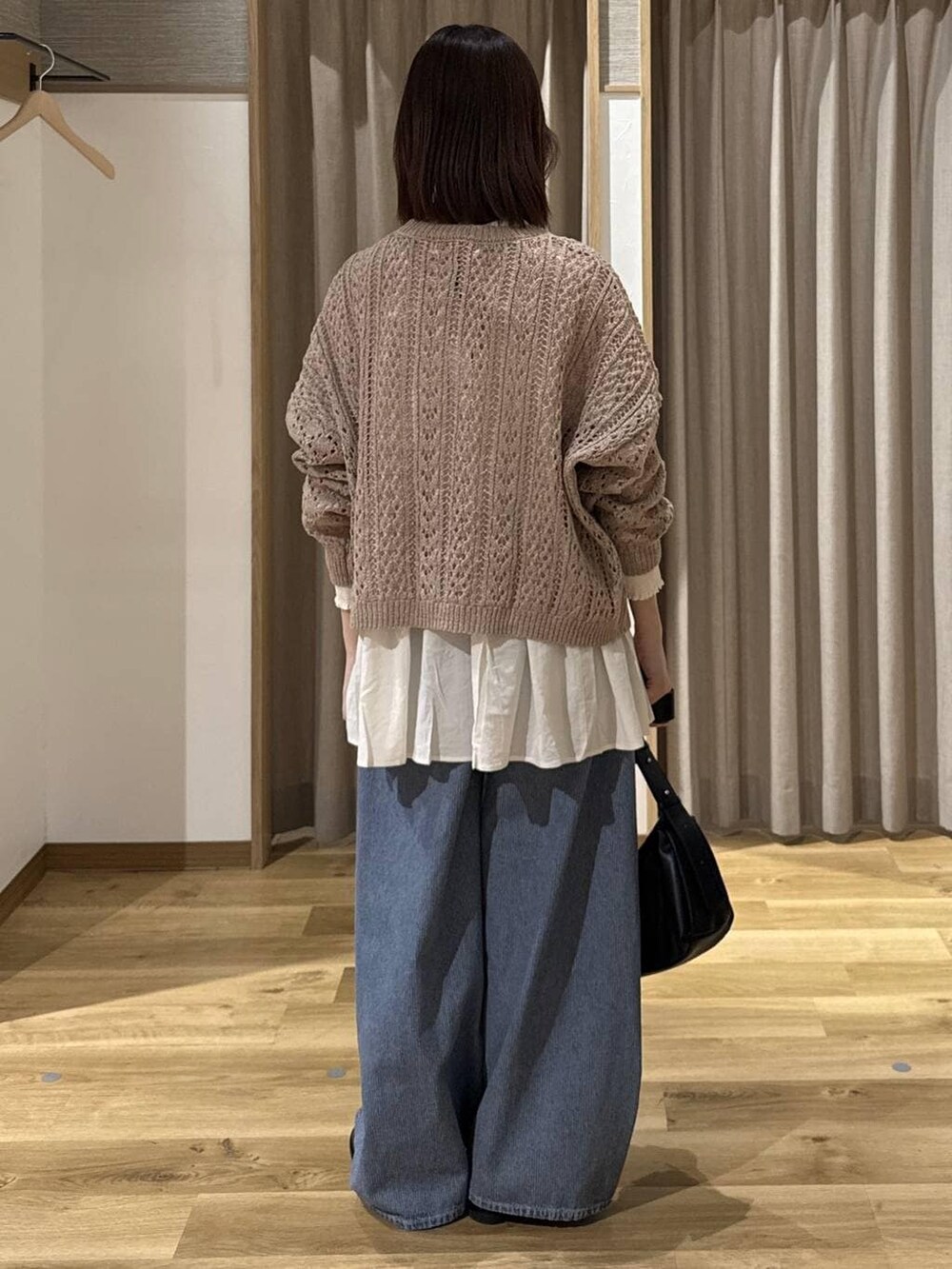 ブルー系のデニムパンツ、ホワイト系のシャツ/ブラウス、ベージュ系のニット/セーターを着用したレディースの冬コーディネートの3枚目の写真