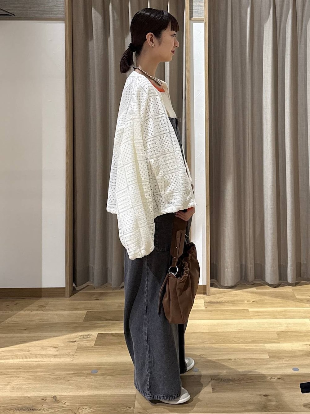 ブラック系のサロペット/オーバーオール、ベージュ系のトートバッグ、ホワイト系のスニーカーを着用したレディースの春コーディネートの5枚目の写真