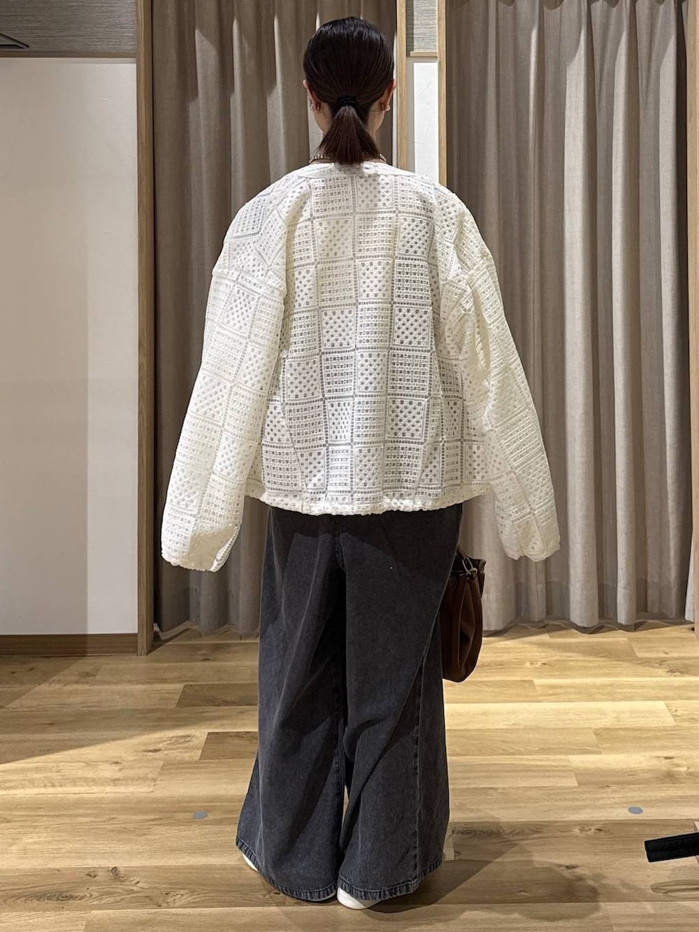 ブラック系のサロペット/オーバーオール、ベージュ系のトートバッグ、ホワイト系のスニーカーを着用したレディースの春コーディネートの4枚目の写真