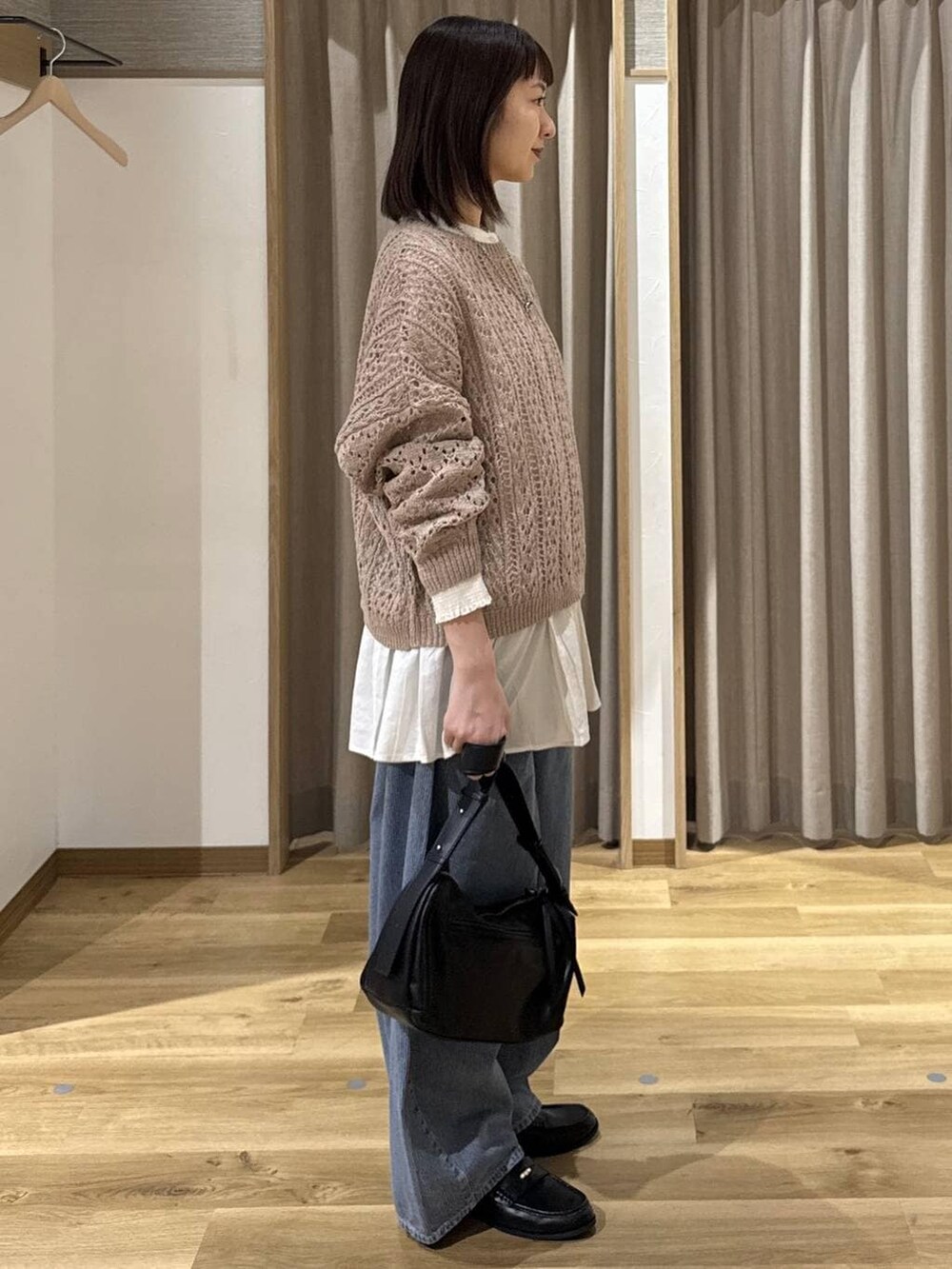 ブルー系のデニムパンツ、ホワイト系のシャツ/ブラウス、ベージュ系のニット/セーターを着用したレディースの冬コーディネートの4枚目の写真