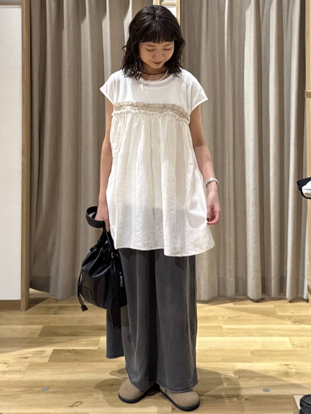 ブラック系のトートバッグ、ブラウン系のその他シューズ、グレー系のスカートを着用したレディースの夏コーディネートの2枚目の写真