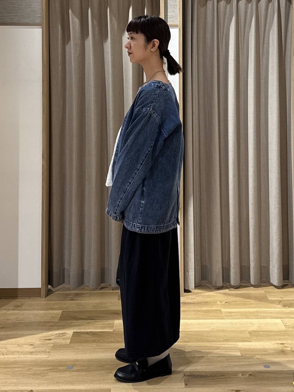 ブルー系のノーカラージャケット、ブラック系のローファー、ブラック系のショルダーバッグを着用したレディースの冬コーディネートの2枚目の写真