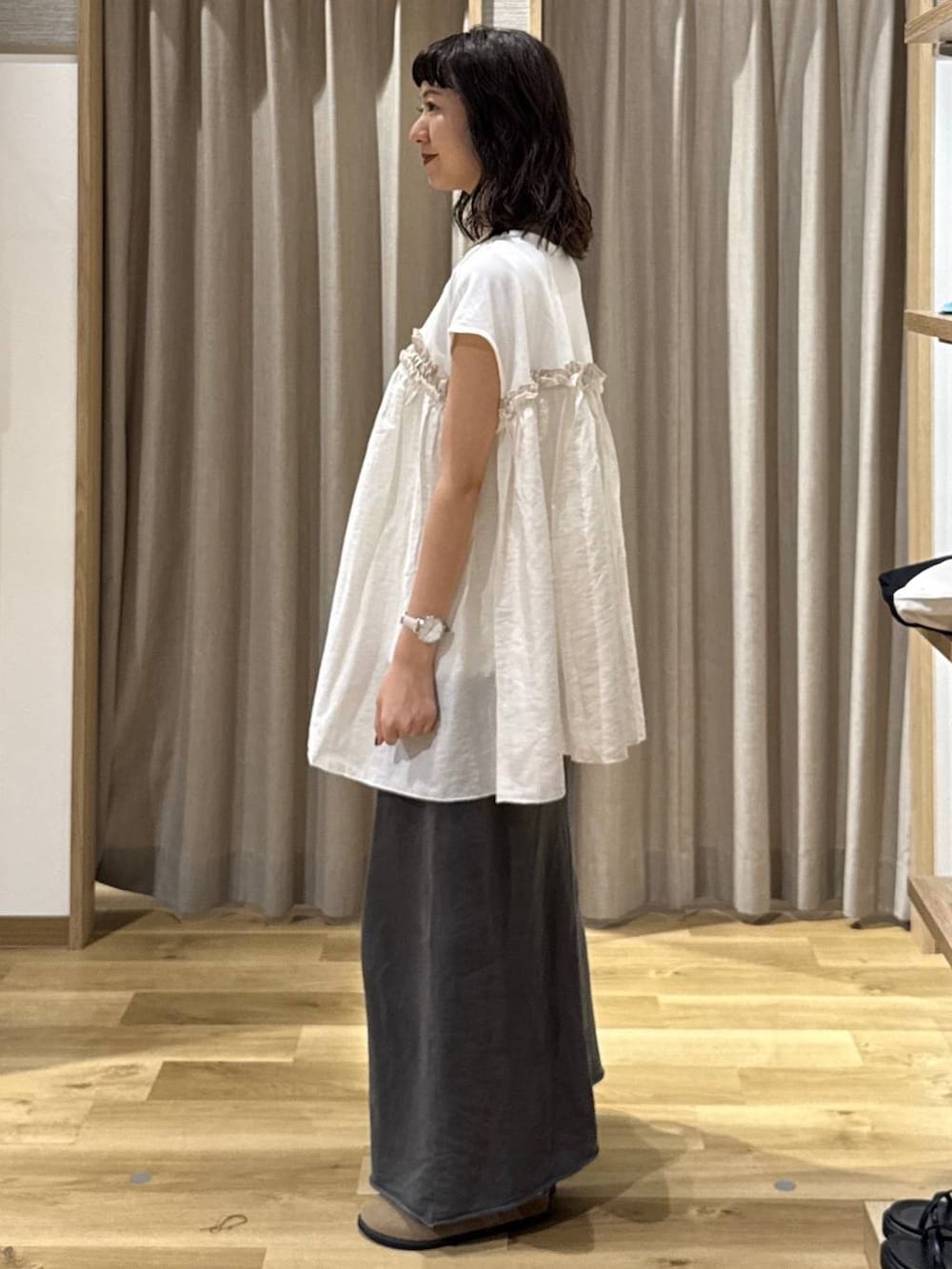 ブラック系のトートバッグ、ブラウン系のその他シューズ、グレー系のスカートを着用したレディースの夏コーディネートの3枚目の写真