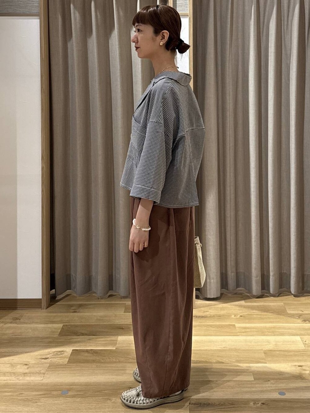 ベージュ系のショルダーバッグ、ブラウン系のその他パンツ、その他のシャツ/ブラウスを着用したレディースの夏コーディネートの3枚目の写真