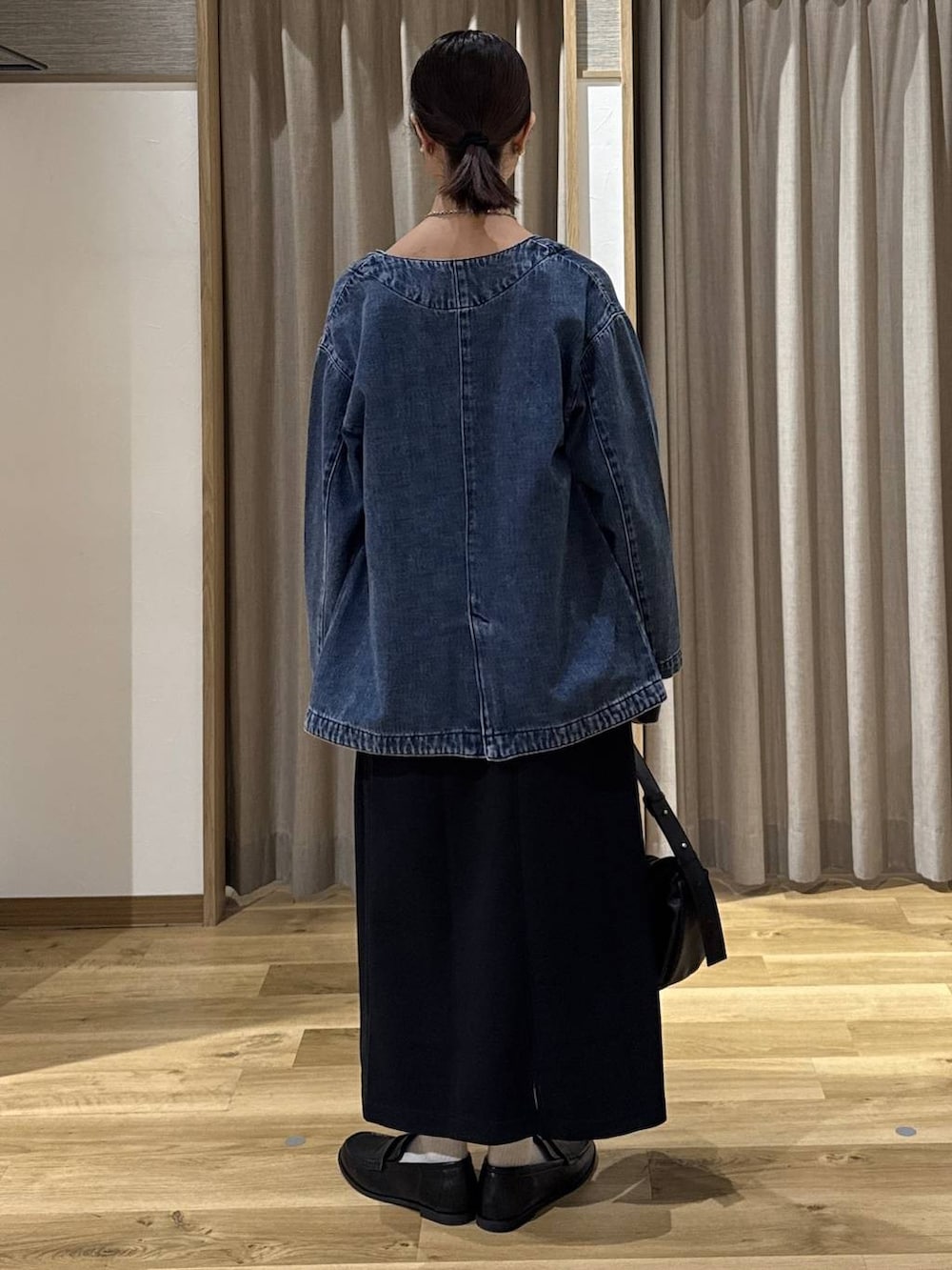 ブルー系のノーカラージャケット、ブラック系のローファー、ブラック系のショルダーバッグを着用したレディースの冬コーディネートの3枚目の写真