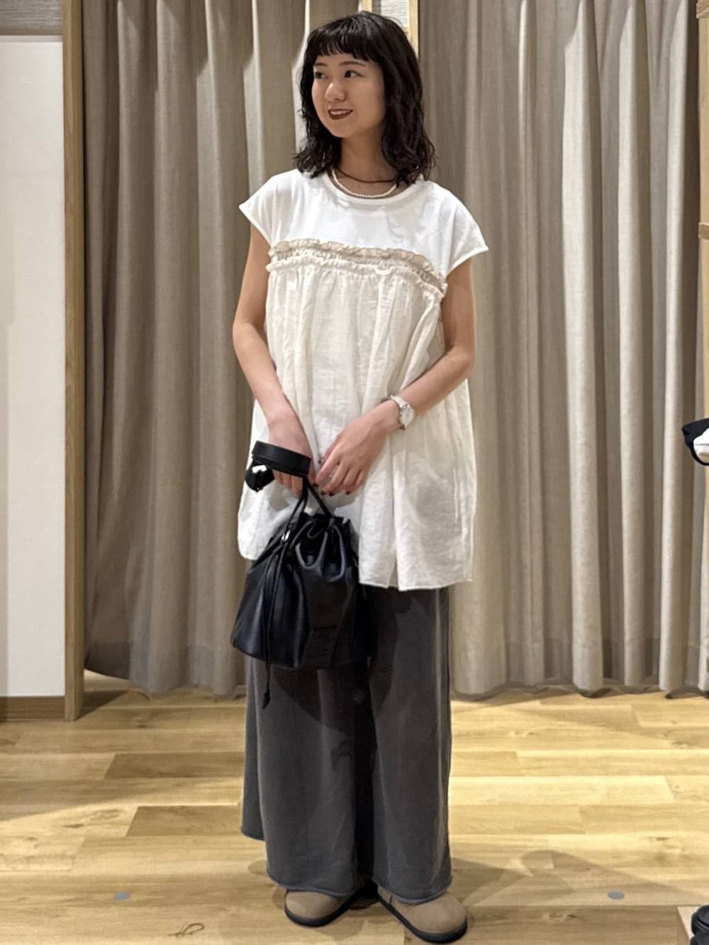 ブラック系のトートバッグ、ブラウン系のその他シューズ、グレー系のスカートを着用したレディースの夏コーディネートの6枚目の写真
