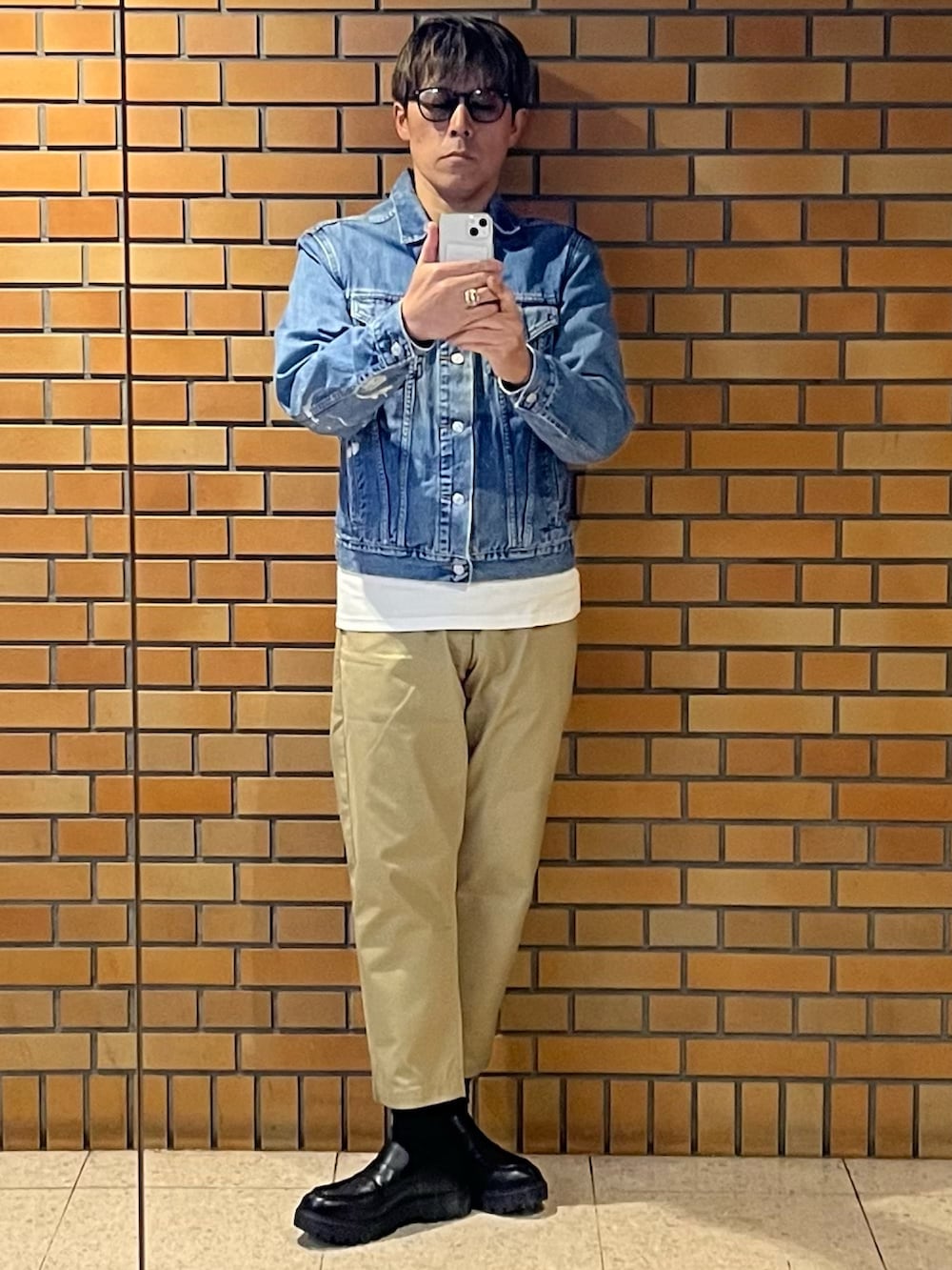 ベージュ系のチノパンツ、ブルー系のデニムジャケット、シルバー系のリングを着用したメンズの秋コーディネートの2枚目の写真