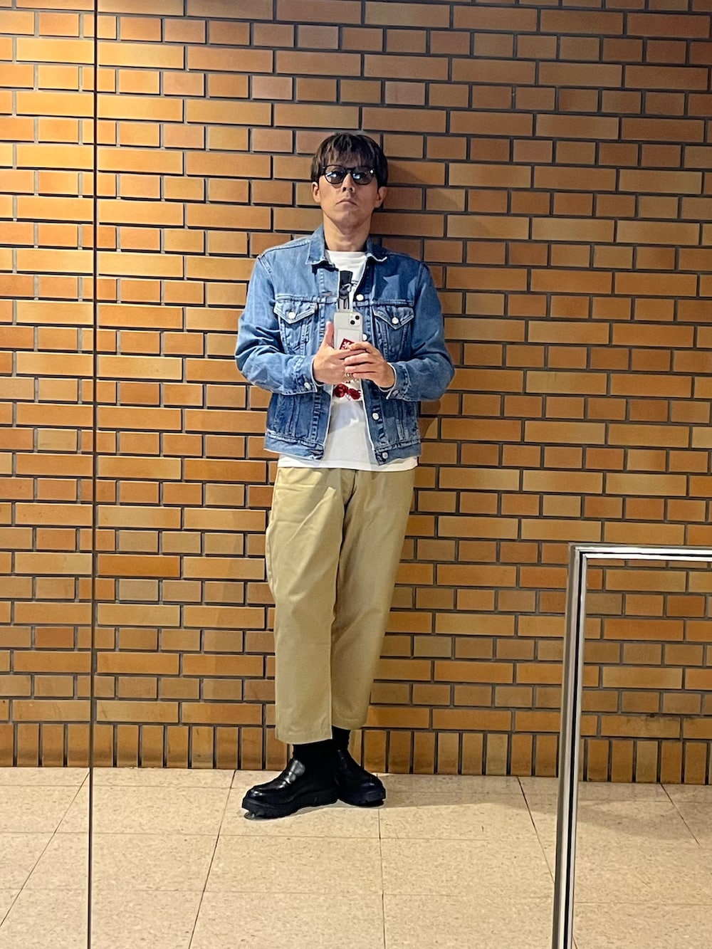 ベージュ系のチノパンツ、ブルー系のデニムジャケット、シルバー系のリングを着用したメンズの秋コーディネートの4枚目の写真