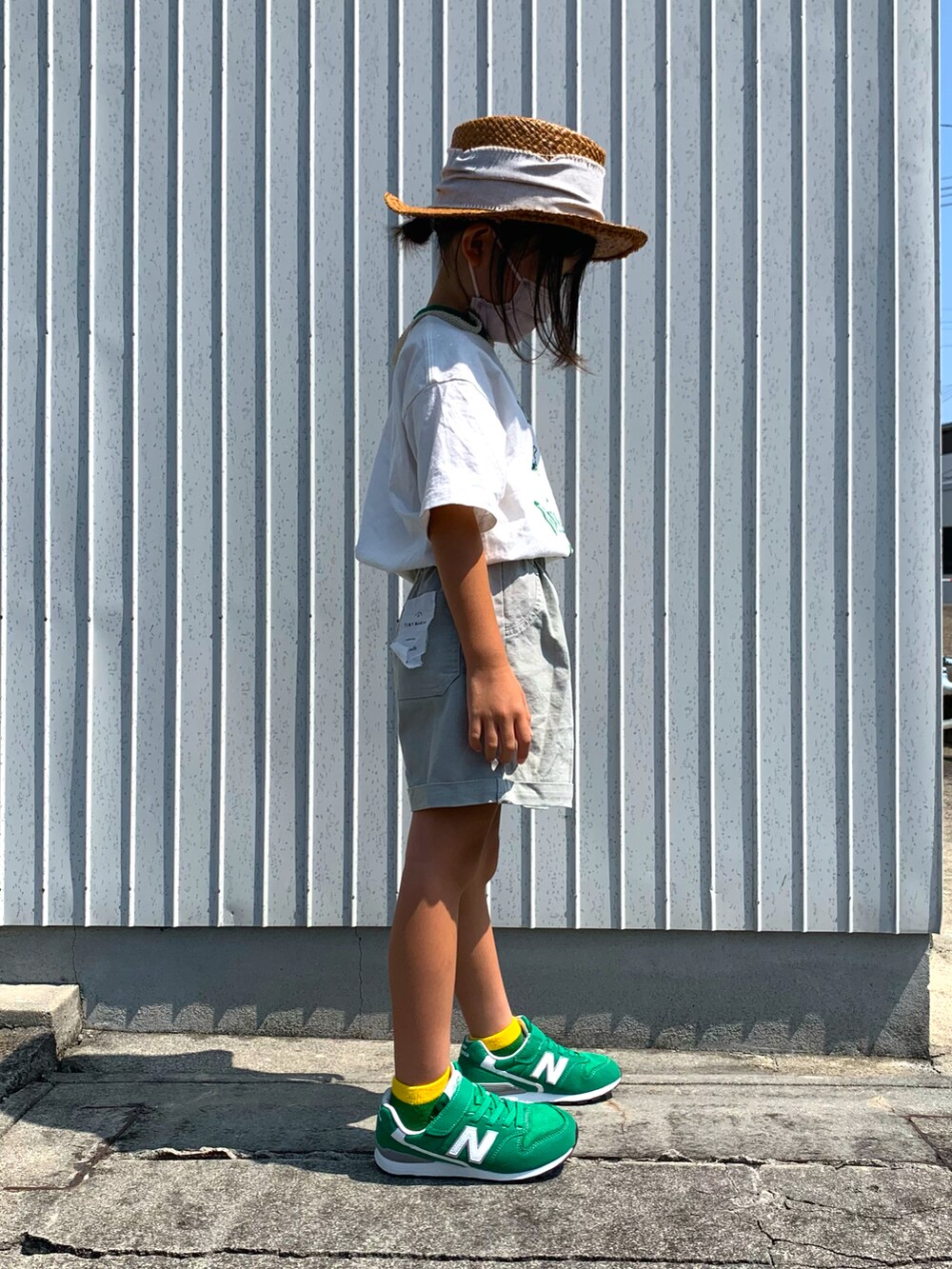 シルバー系のチノパンツ、グリーン系のスニーカー、ホワイト系のTシャツ/カットソーを着用したキッズの秋コーディネートの2枚目の写真