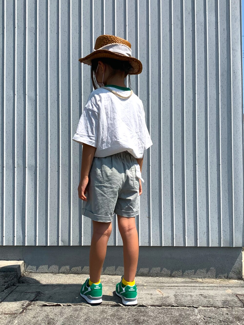 シルバー系のチノパンツ、グリーン系のスニーカー、ホワイト系のTシャツ/カットソーを着用したキッズの秋コーディネートの3枚目の写真