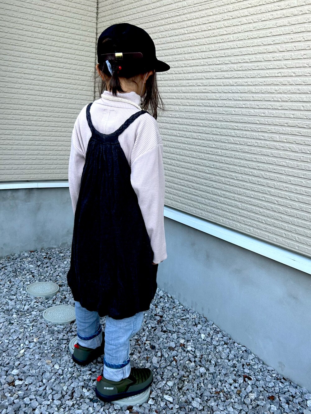 ベージュ系のトップス、ブルー系のデニムパンツ、ブラック系のトップスを着用したキッズの秋コーディネートの2枚目の写真