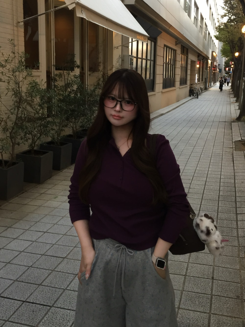 シルバー系のスニーカー、ブラウン系のショルダーバッグ、パープル系のTシャツ/カットソーを着用したレディースの秋コーディネートの2枚目の写真