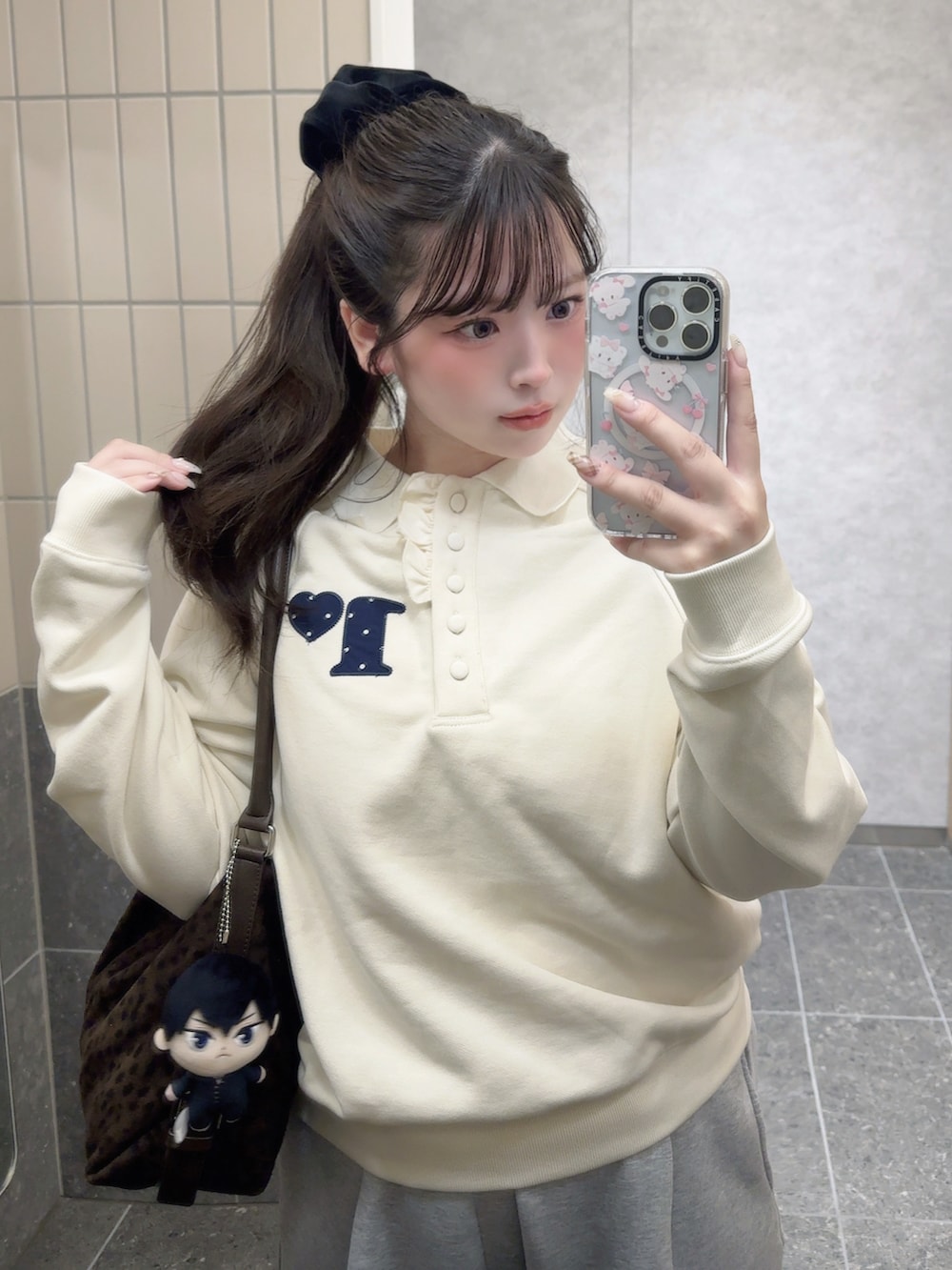 ホワイト系のポロシャツ、グレー系のスウェットパンツ、その他のショルダーバッグを着用したレディースの冬コーディネートの2枚目の写真