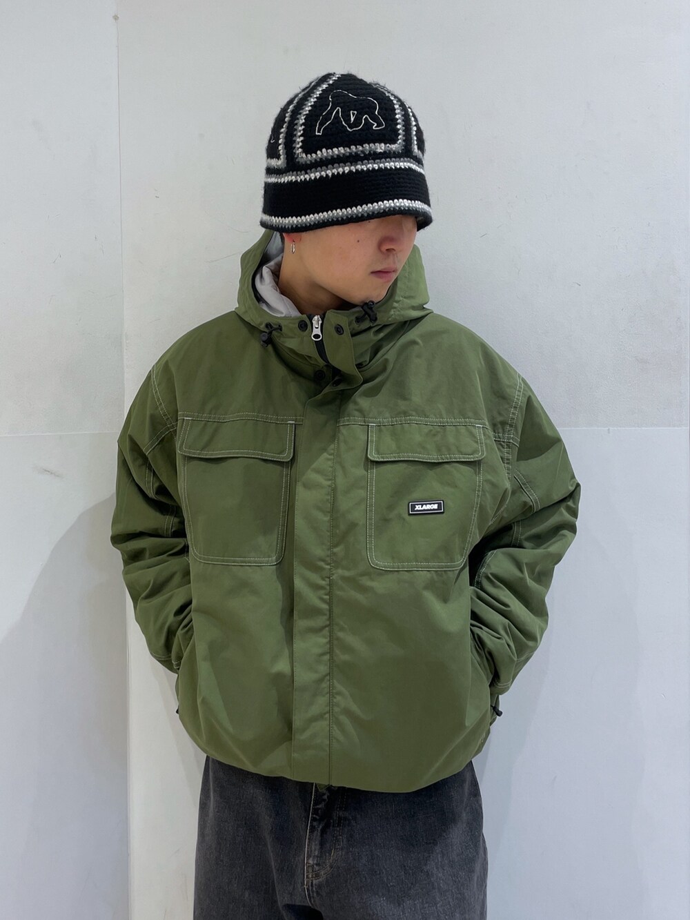 グリーン系のその他アウター、ブラック系のハットを着用したメンズの冬コーディネートの5枚目の写真