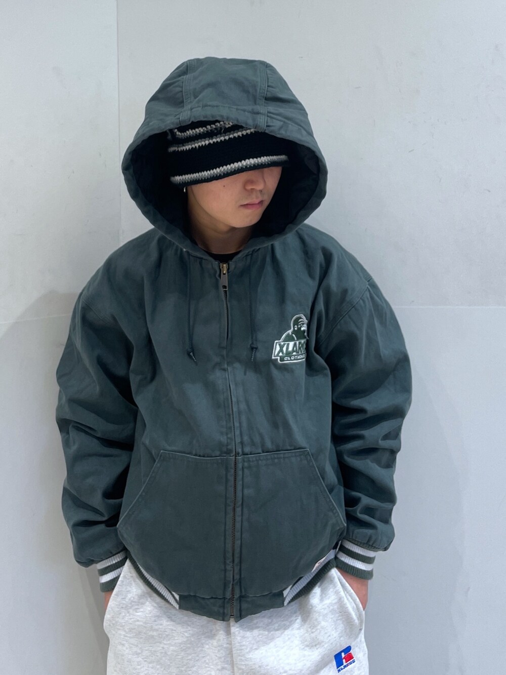 グリーン系のブルゾン、グレー系のスウェットパンツを着用したメンズの冬コーディネートの5枚目の写真