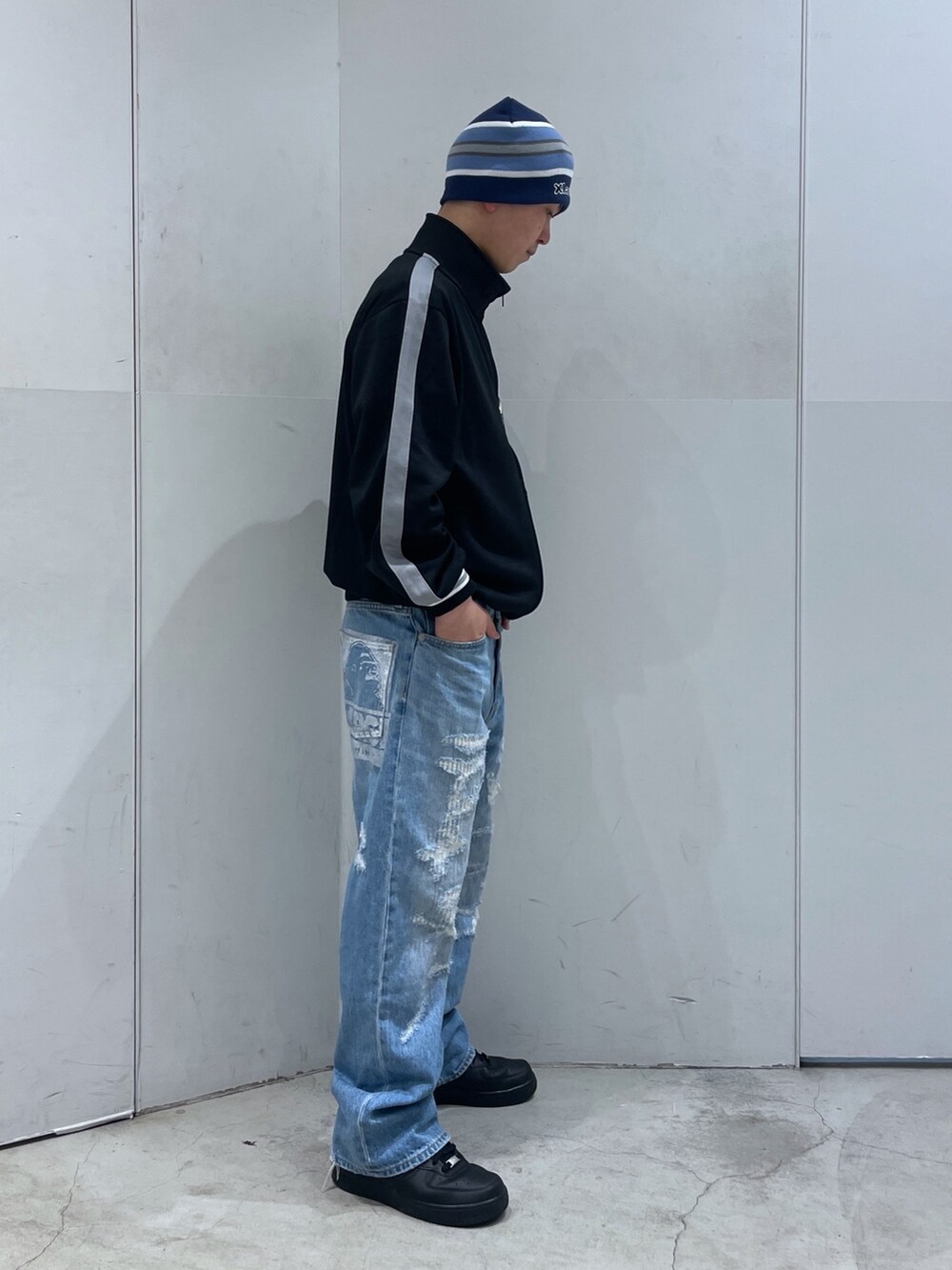 ブラック系のブルゾン、ブルー系のデニムパンツ、ブルー系のニットキャップ/ビーニーを着用したメンズの冬コーディネートの3枚目の写真