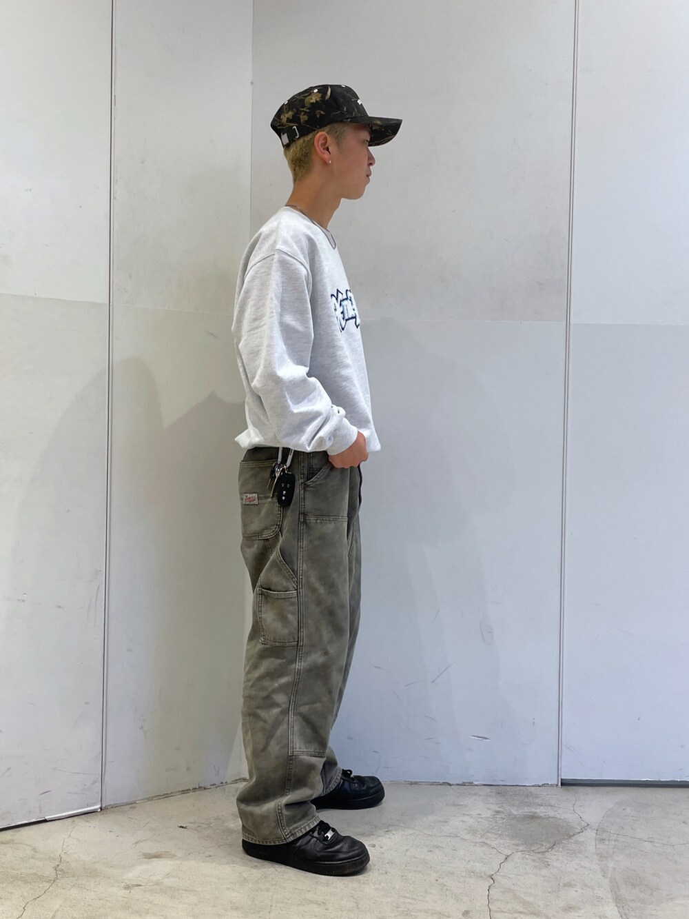 グレー系のスウェット、グリーン系のデニムパンツを着用したメンズの秋コーディネートの2枚目の写真