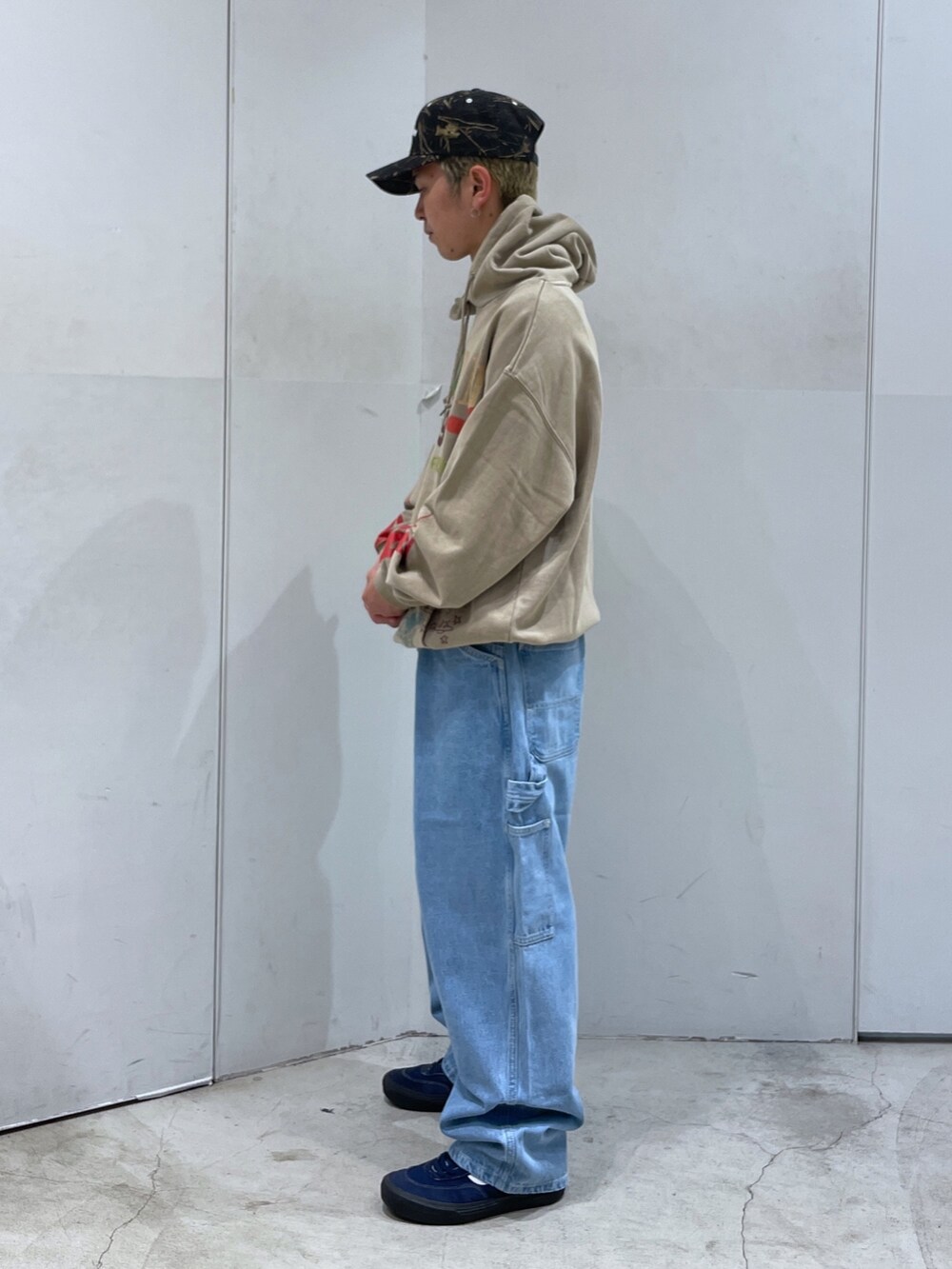 ベージュ系のパーカー、ブルー系のデニムパンツを着用したメンズの秋コーディネートの4枚目の写真