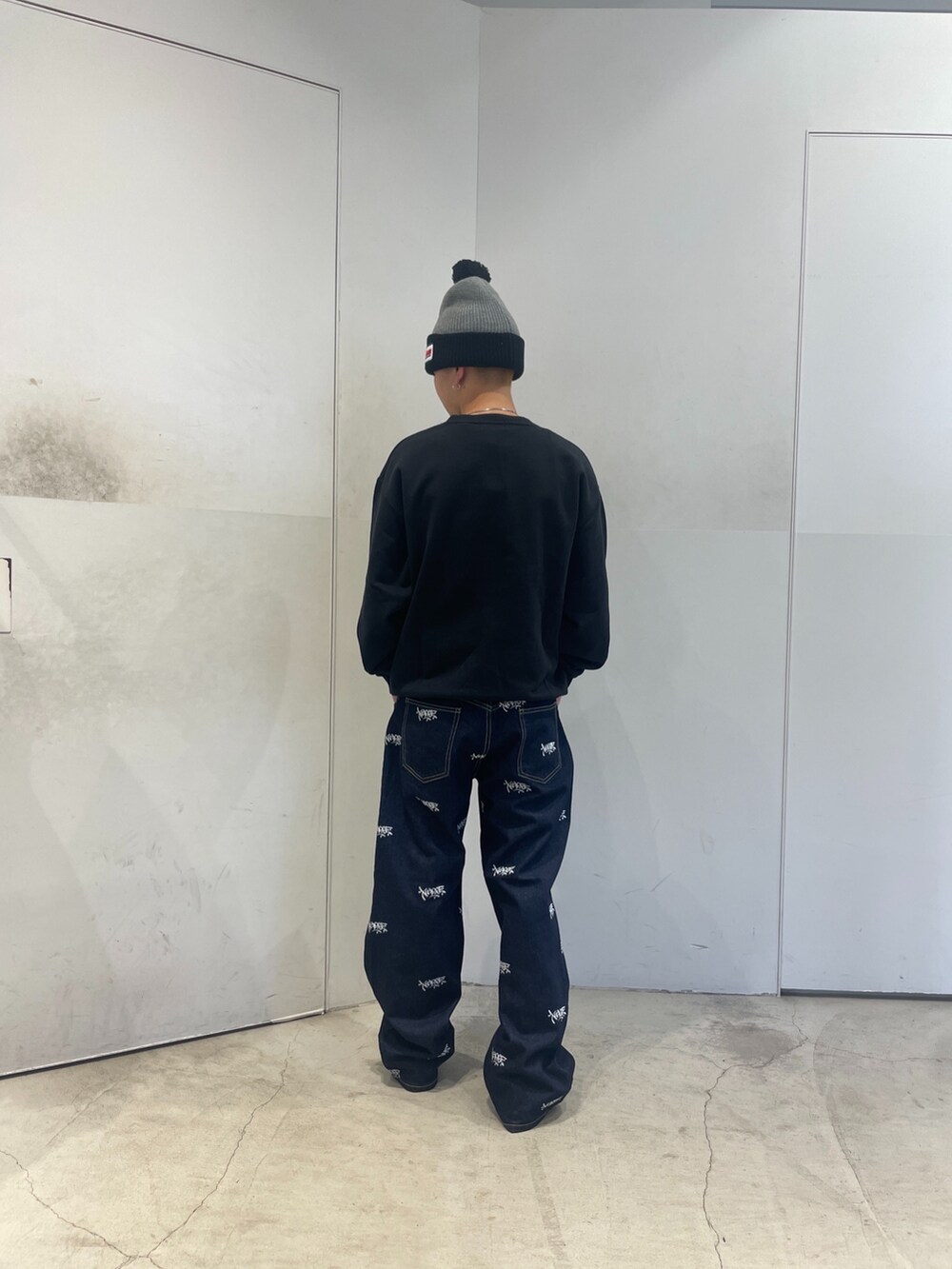 ブラック系のスウェット、ブルー系のデニムパンツ、グレー系のニットキャップ/ビーニーを着用したメンズの秋コーディネートの4枚目の写真