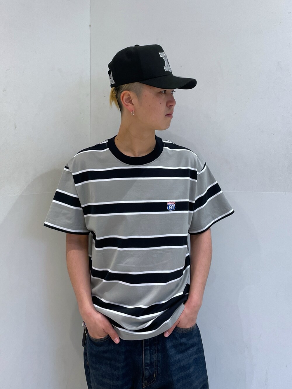 グレー系のTシャツ/カットソー、ブルー系のデニムパンツを着用したメンズの春コーディネートの5枚目の写真