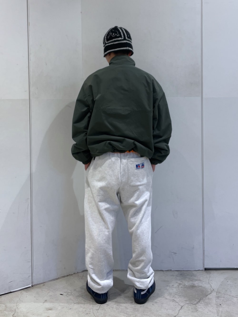 グリーン系のブルゾン、グレー系のスウェットパンツ、ブラック系のハットを着用したメンズの冬コーディネートの3枚目の写真