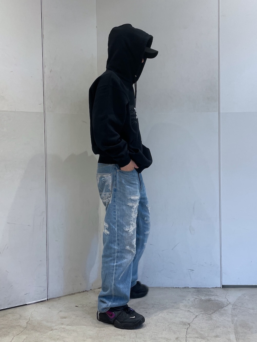 ブラック系のパーカー、ブルー系のデニムパンツを着用したメンズの冬コーディネートの2枚目の写真